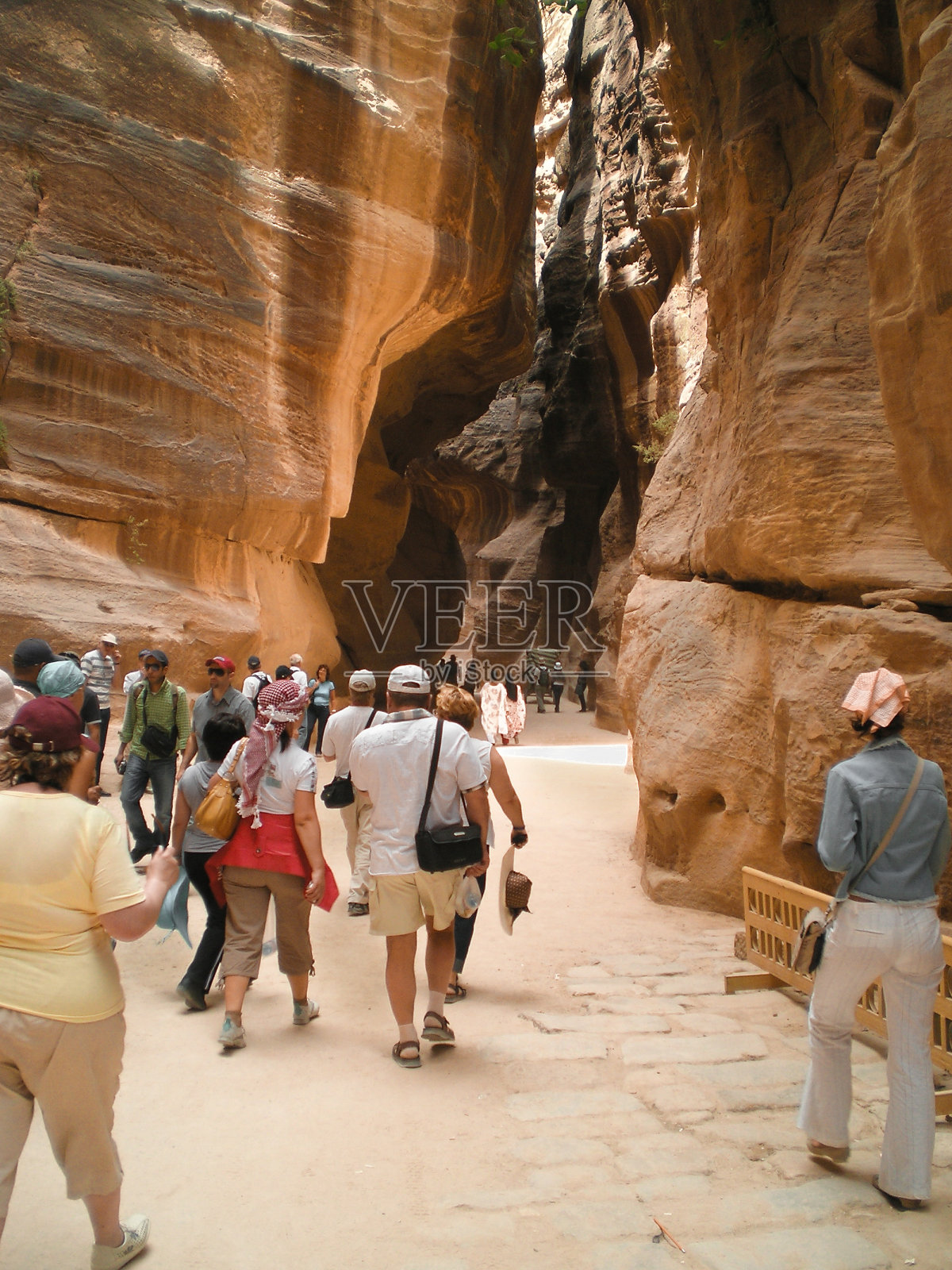 游客沿着约旦佩特拉历史保护区的Al Siq峡谷行走照片摄影图片
