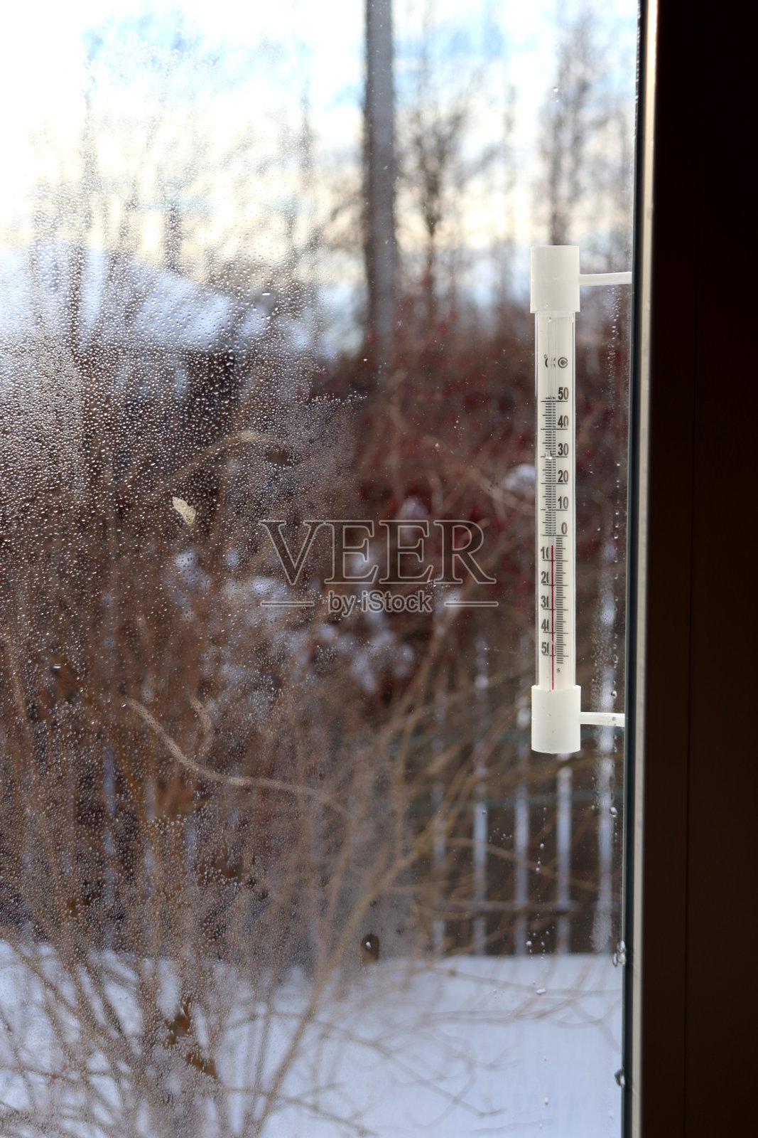 一座乡村房屋的窗户外，一个复古的塑料温度计照片摄影图片