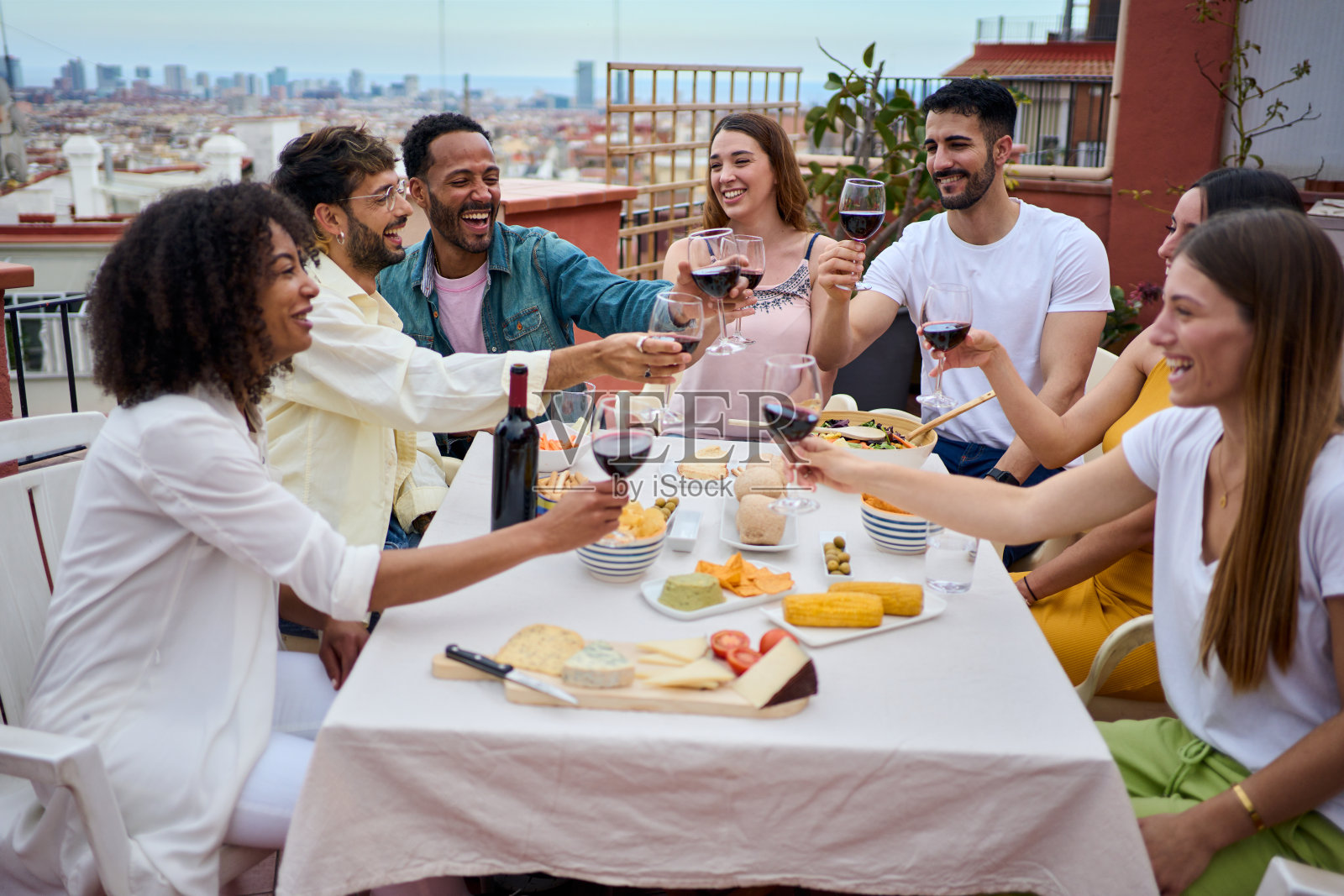 一群快乐的年轻人在屋顶上举杯庆祝照片摄影图片