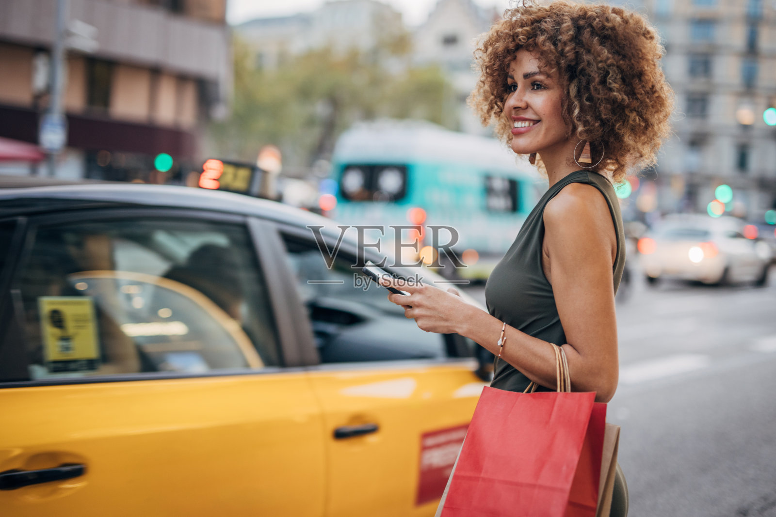都市生活方式:微笑的女人拿着购物袋和智能手机照片摄影图片