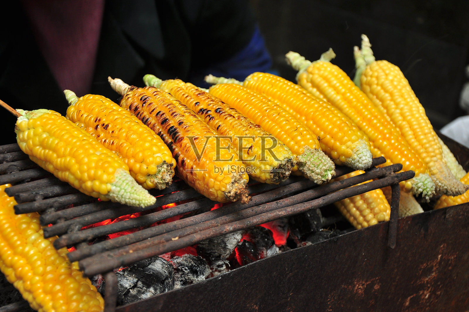 烤架上的烤玉米，可以上桌了。照片摄影图片