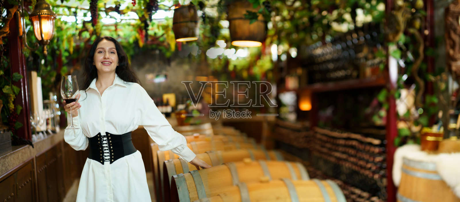 美丽的白女人在试酒。照片摄影图片