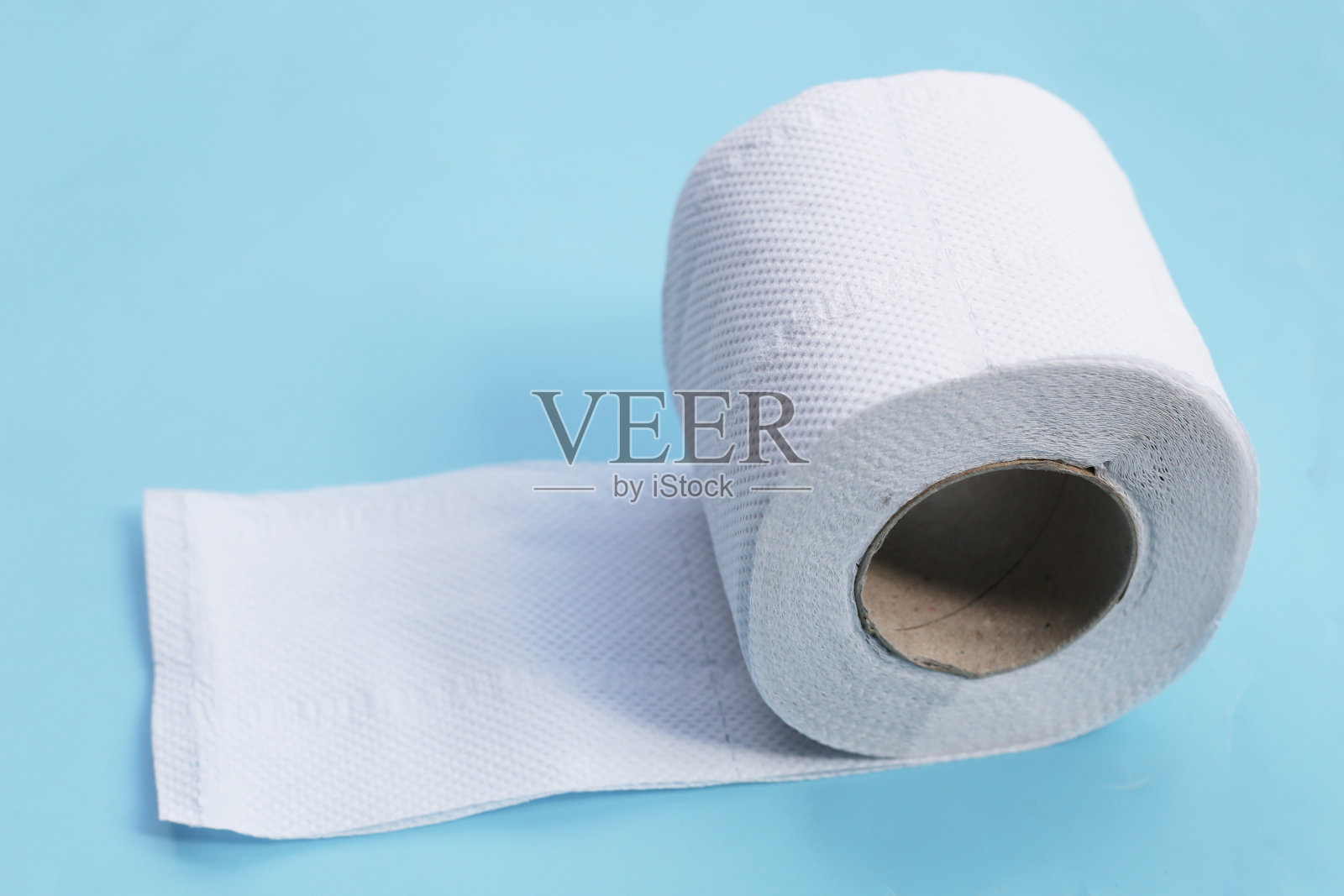 蓝色背景的厕纸。照片摄影图片
