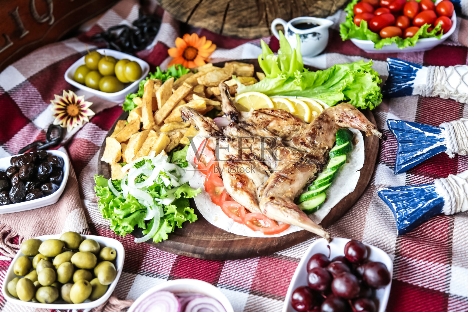 餐桌上的一盘食物，有橄榄、西红柿和生菜照片摄影图片