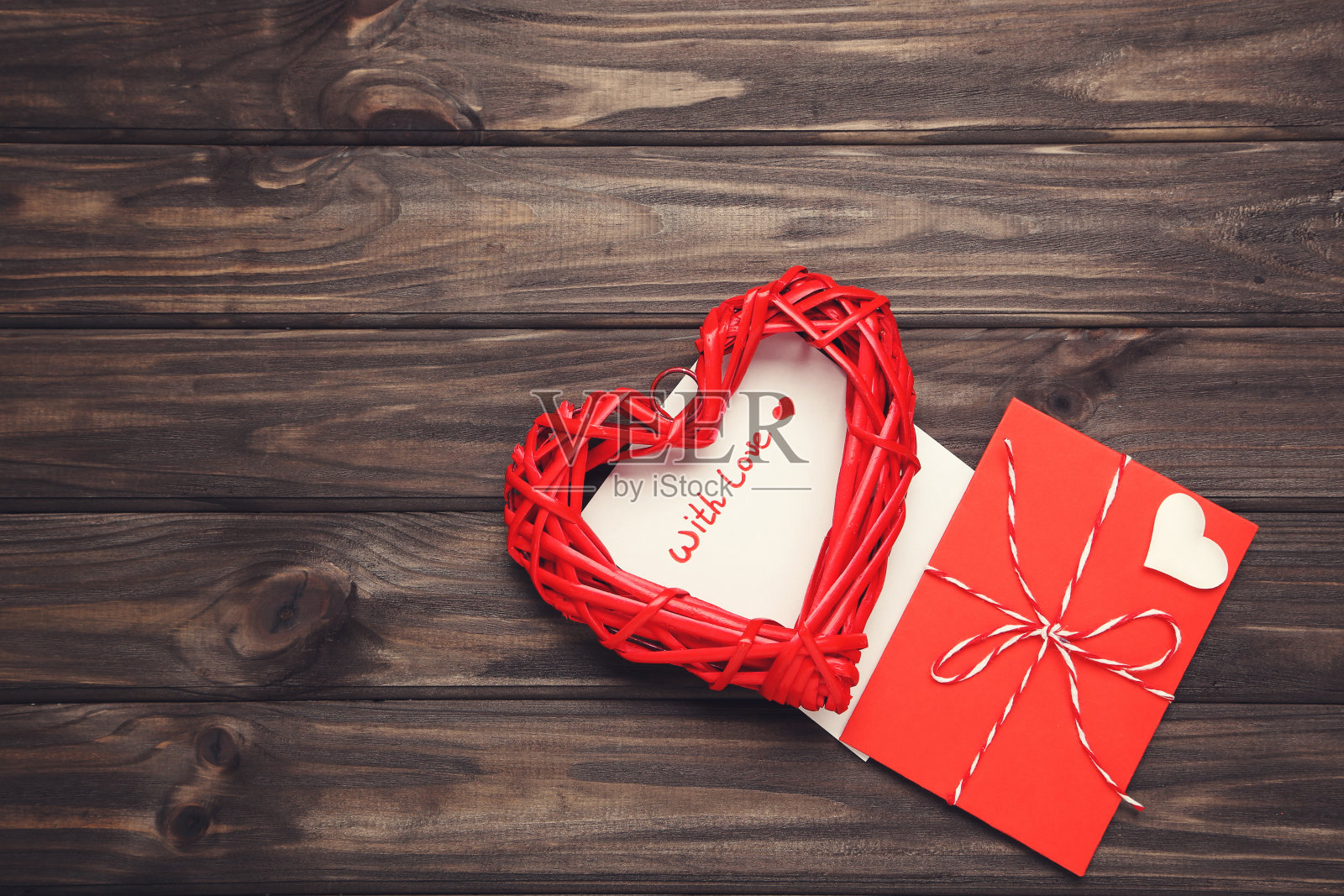 木制桌子上的纸信封上有红心和“爱”字样照片摄影图片