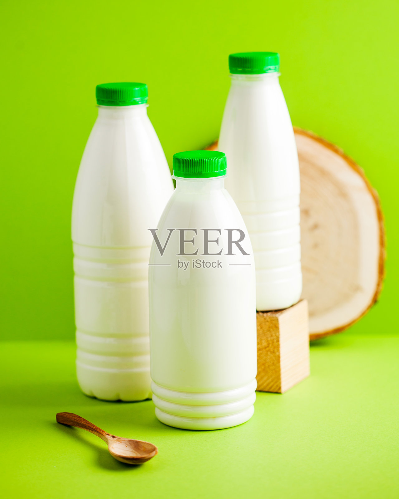 三套奶瓶，绿色瓶盖，象征新鲜和健康。奶产品。牛奶照片摄影图片