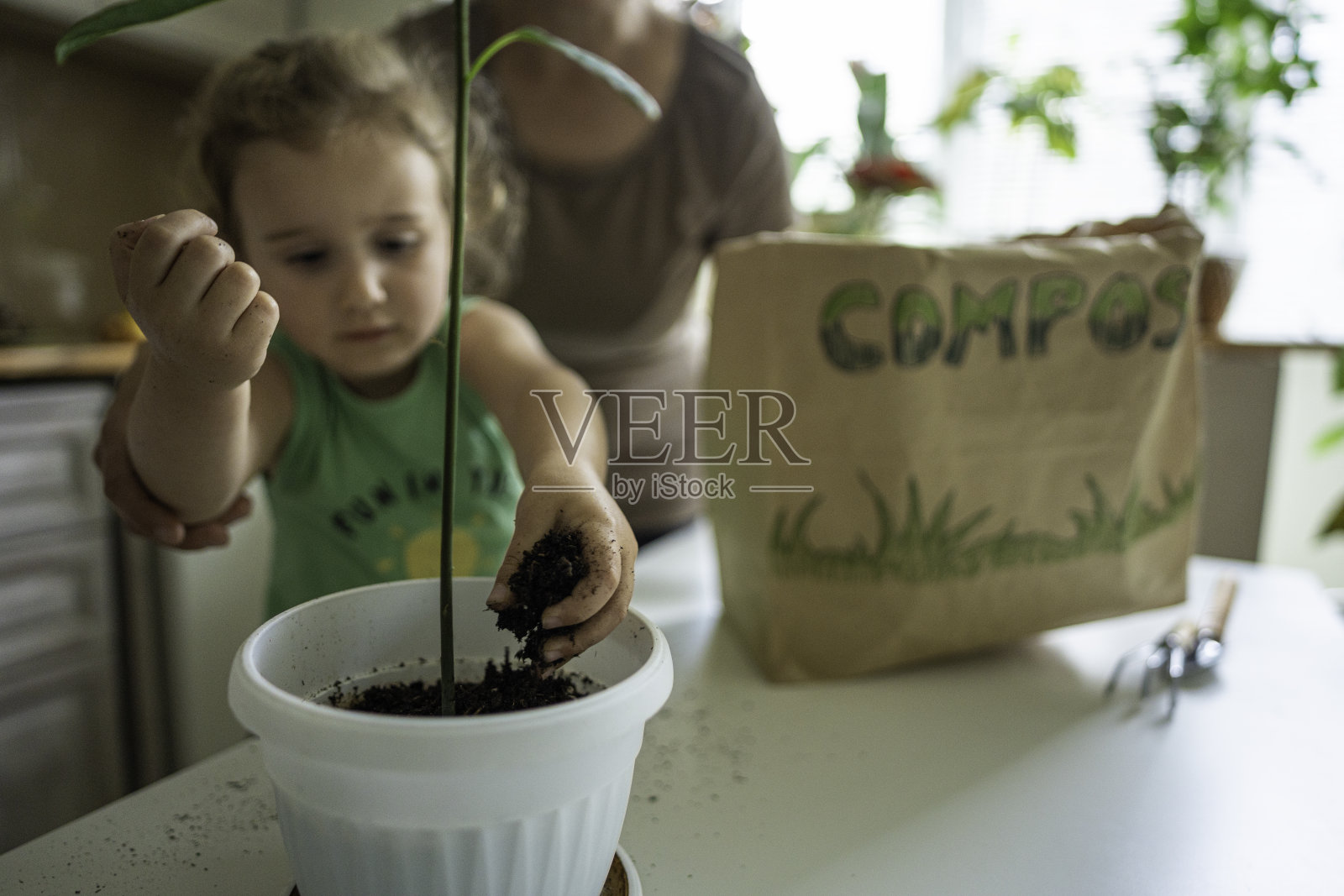 孩子和妈妈一起园艺。照片摄影图片