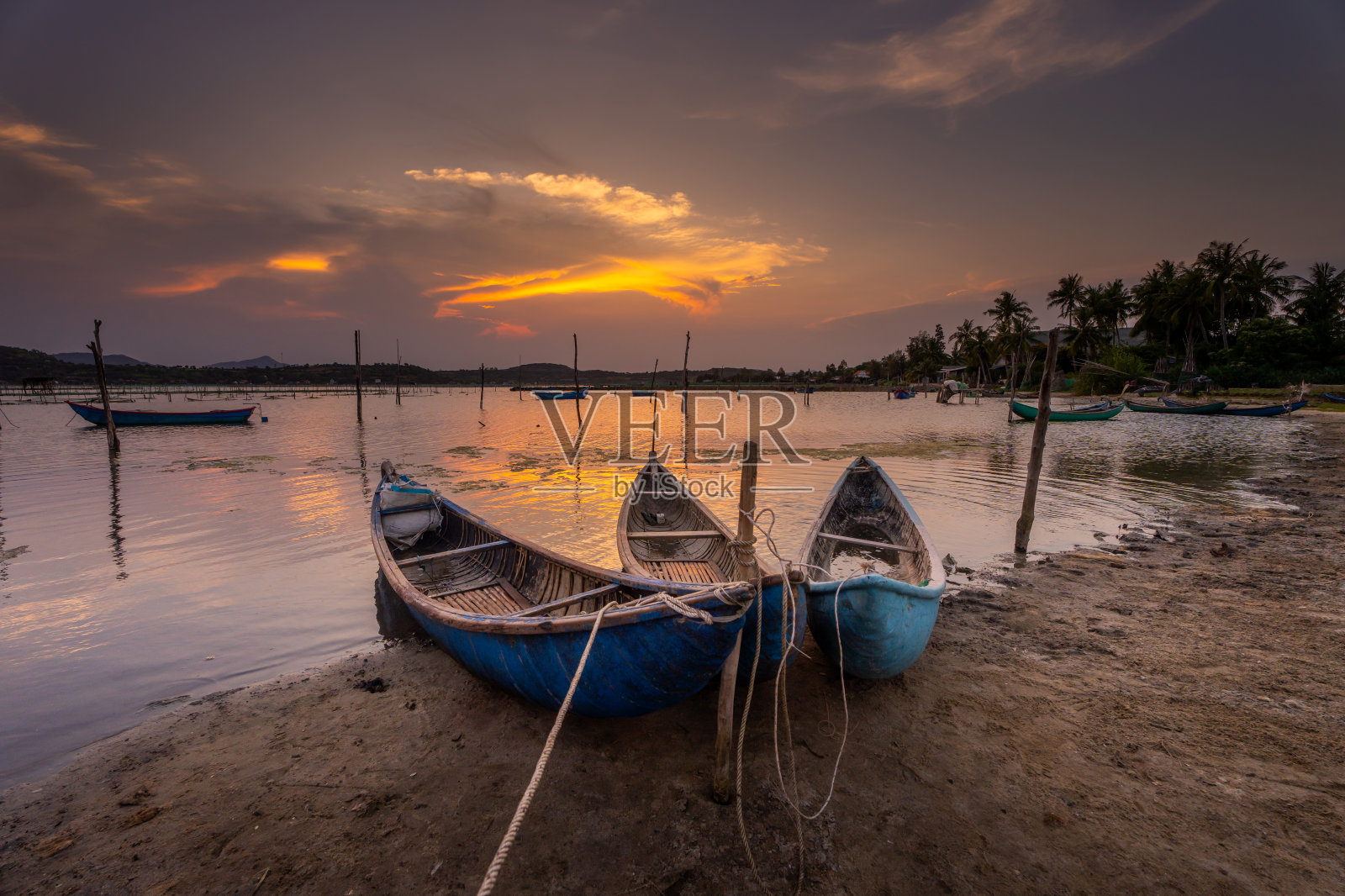 日落时分，越南富颜省O Loan泻湖上的传统船只照片摄影图片