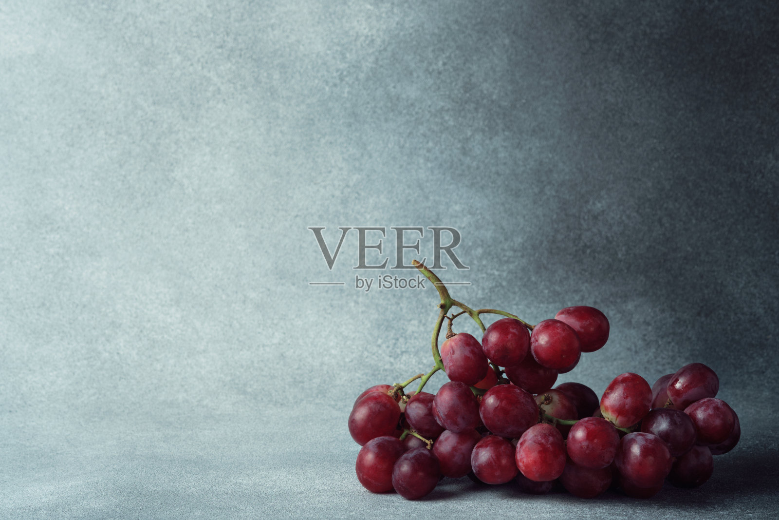 充满活力的红色葡萄束纹理灰色表面与文本的空间照片摄影图片