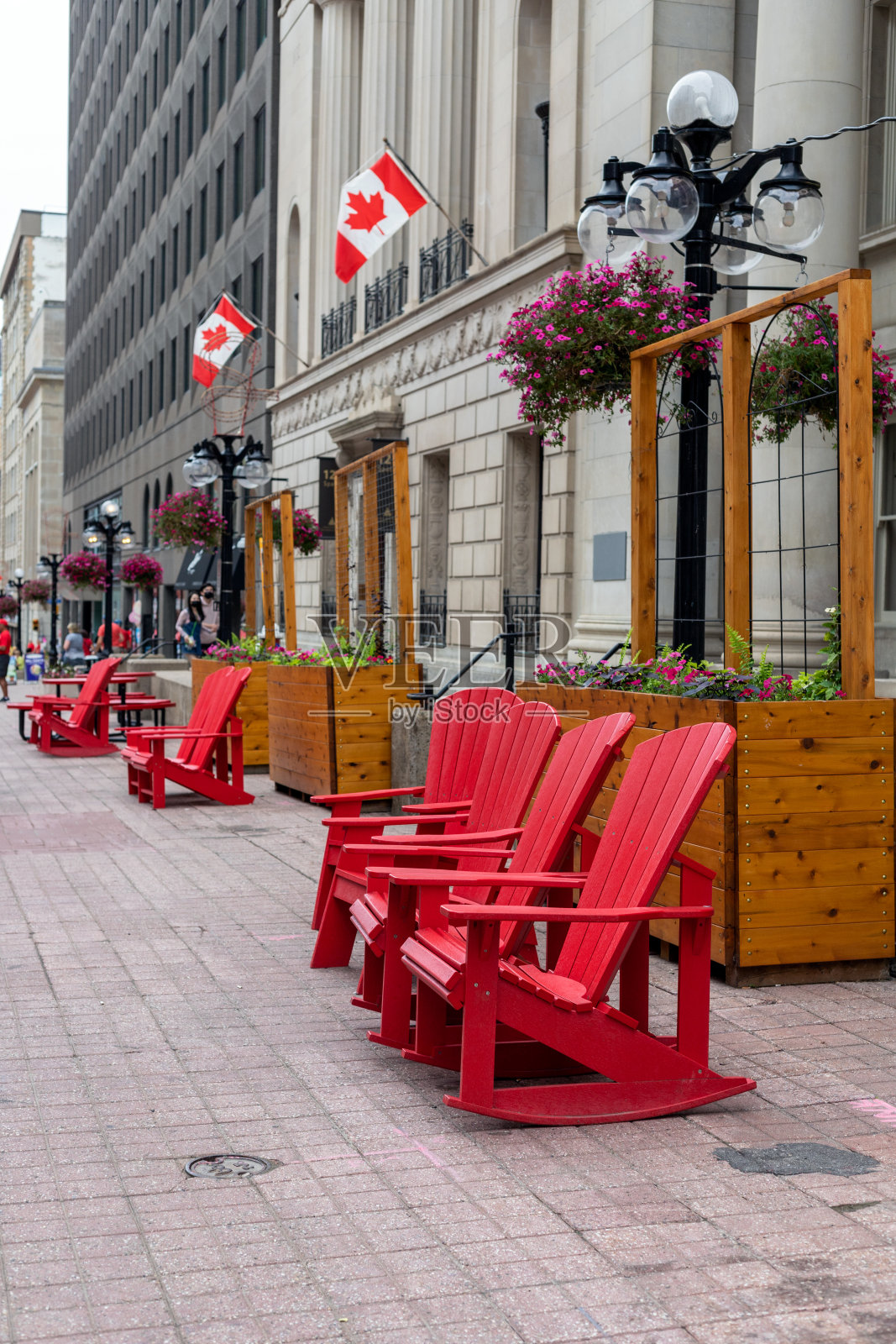 加拿大渥太华市中心斯帕克斯街建筑物附近的红色户外椅子。照片摄影图片