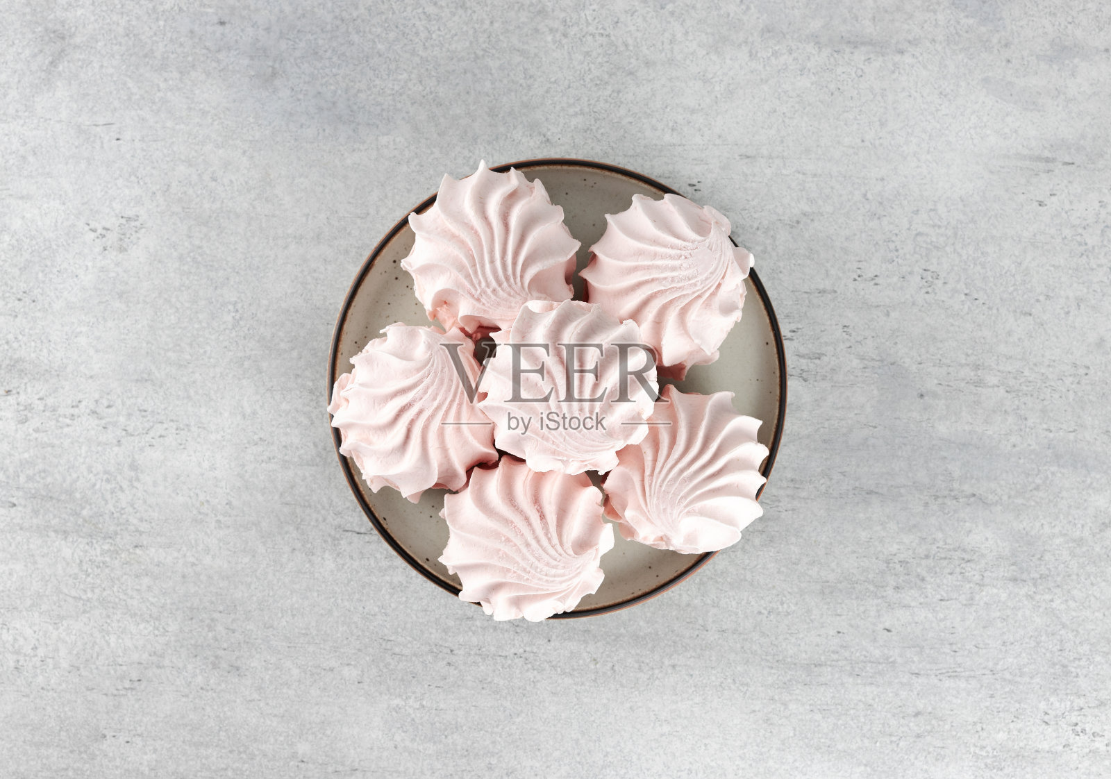 俄罗斯甜点-粉红色棉花糖和风在灰色背景。蛋白霜，蛋奶酥甜点。前视图。照片摄影图片