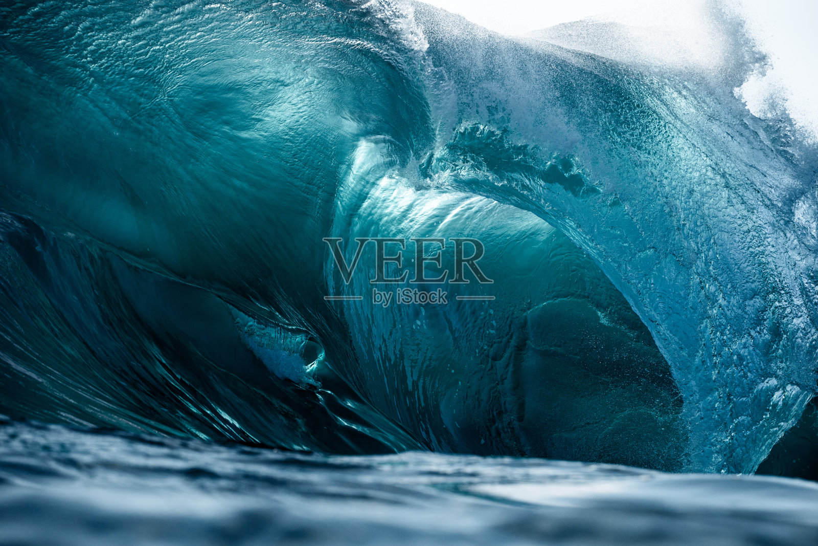 一个明亮的蓝色波浪在浅滩上翻滚照片摄影图片