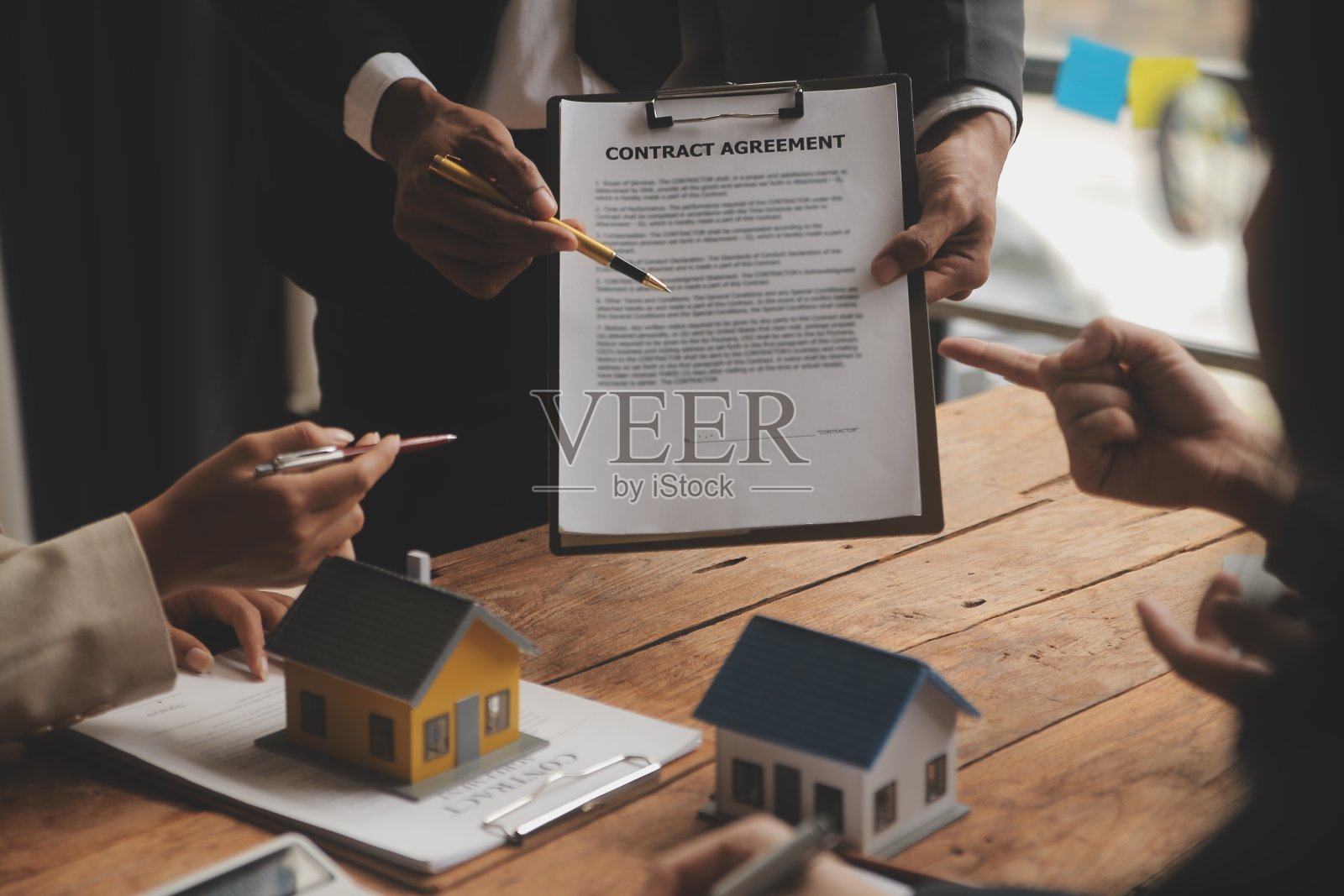 房地产经纪人和销售经理团队分析租赁合同、买卖协议、按揭贷款报价和房屋保险的定价。照片摄影图片