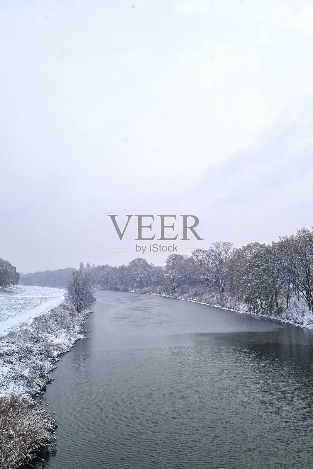 多云的冬日里的河景。照片摄影图片