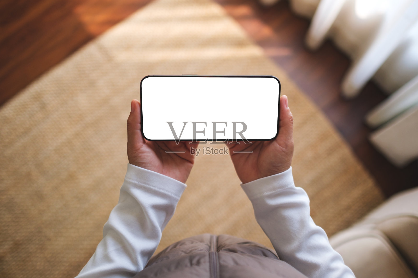 俯视图的模型图像，一个女人拿着手机与空白桌面白色屏幕照片摄影图片