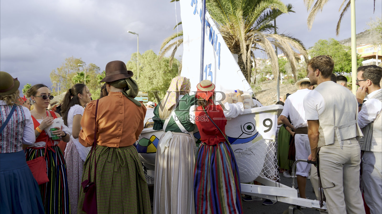 身着五颜六色的传统服装的妇女陪伴着民间花车照片摄影图片
