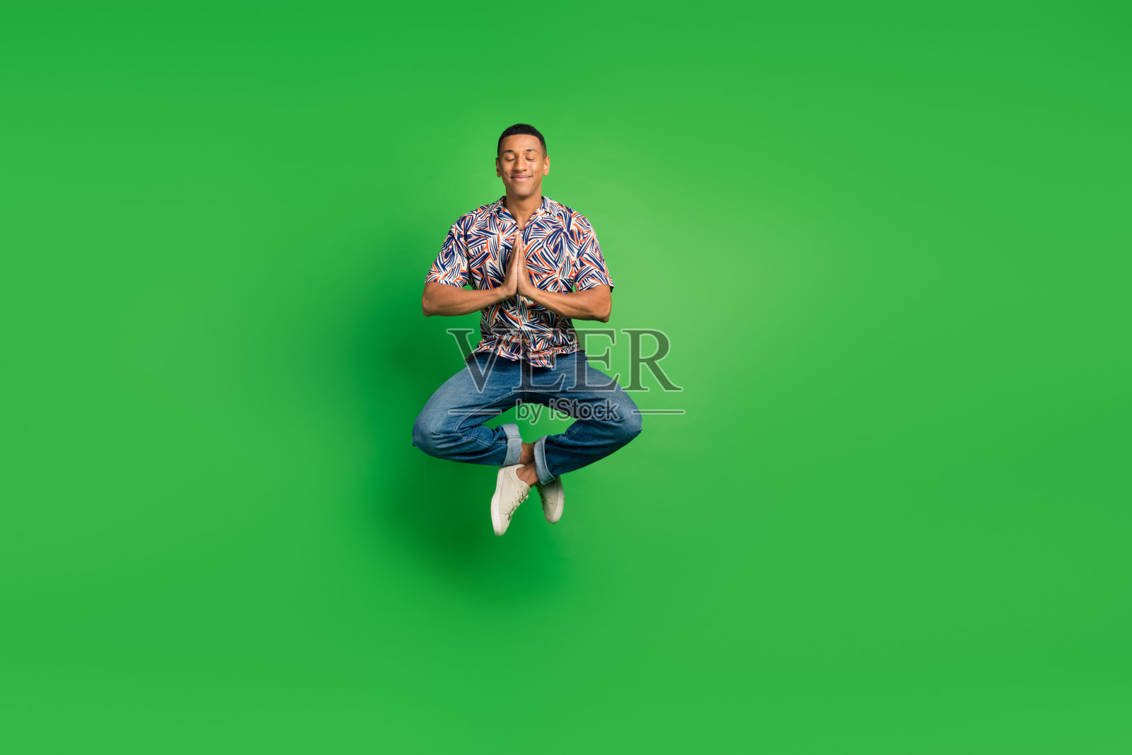 全神贯注的男子练习瑜伽冥想莲花姿势孤立在绿色背景的全长照片照片摄影图片