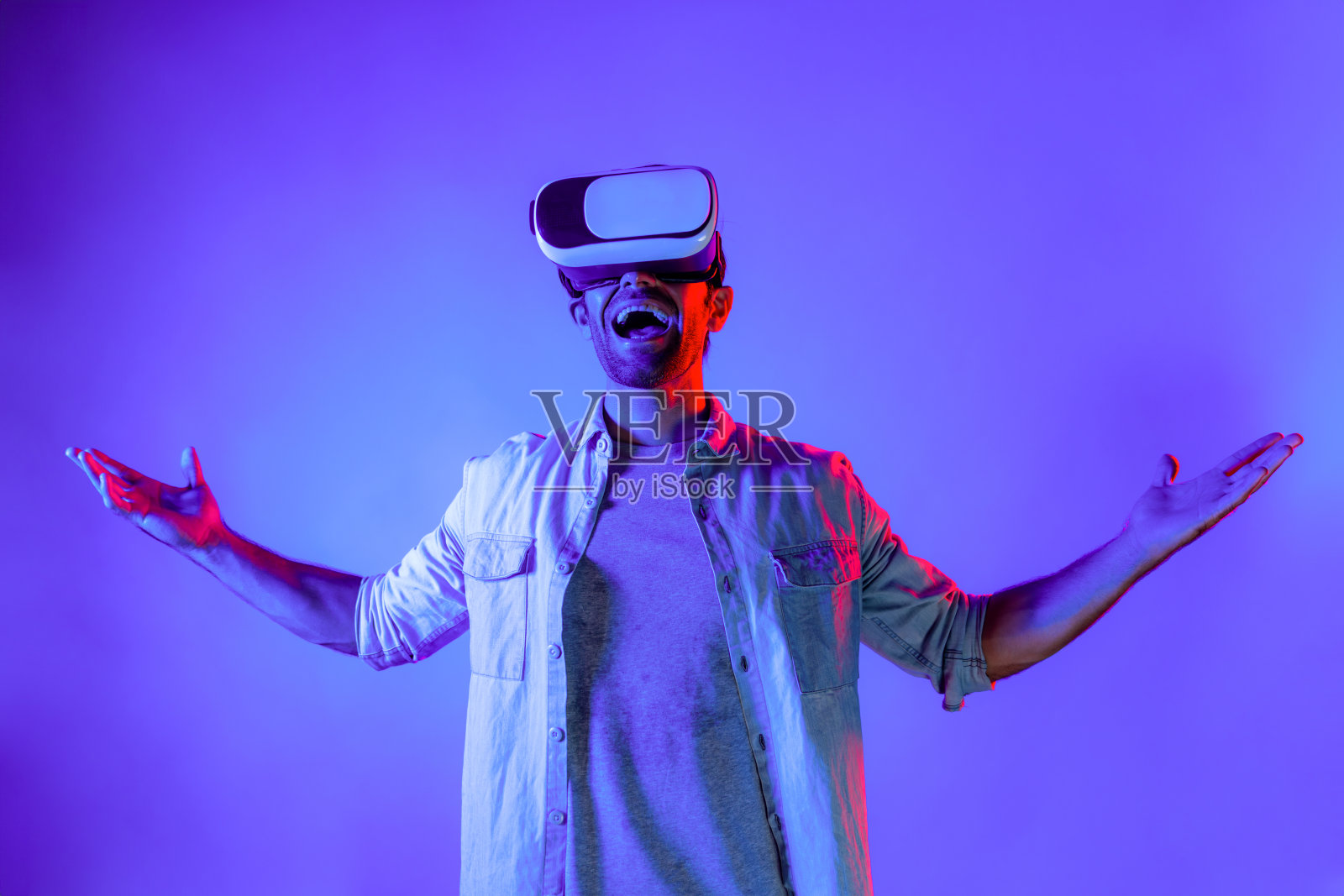 微笑的男子戴着VR眼镜，进入虚拟现实世界。偏差。照片摄影图片