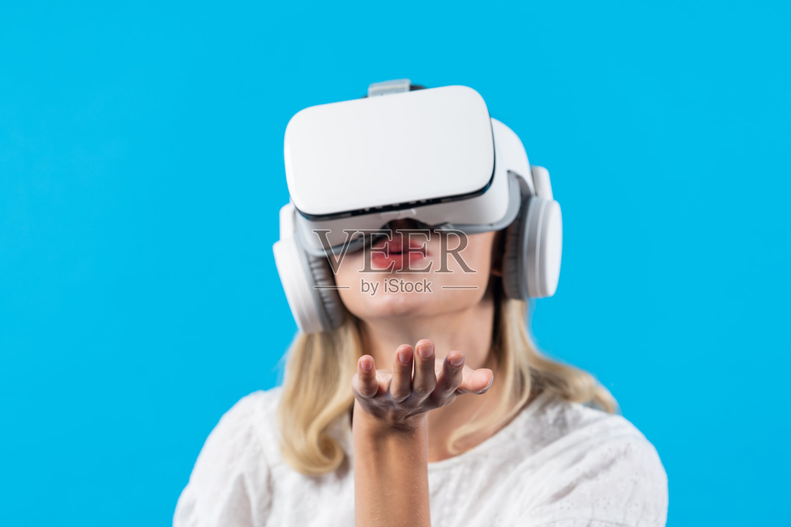 戴着虚拟现实眼镜，站着拿着东西的快乐女孩。精巧的设计。照片摄影图片