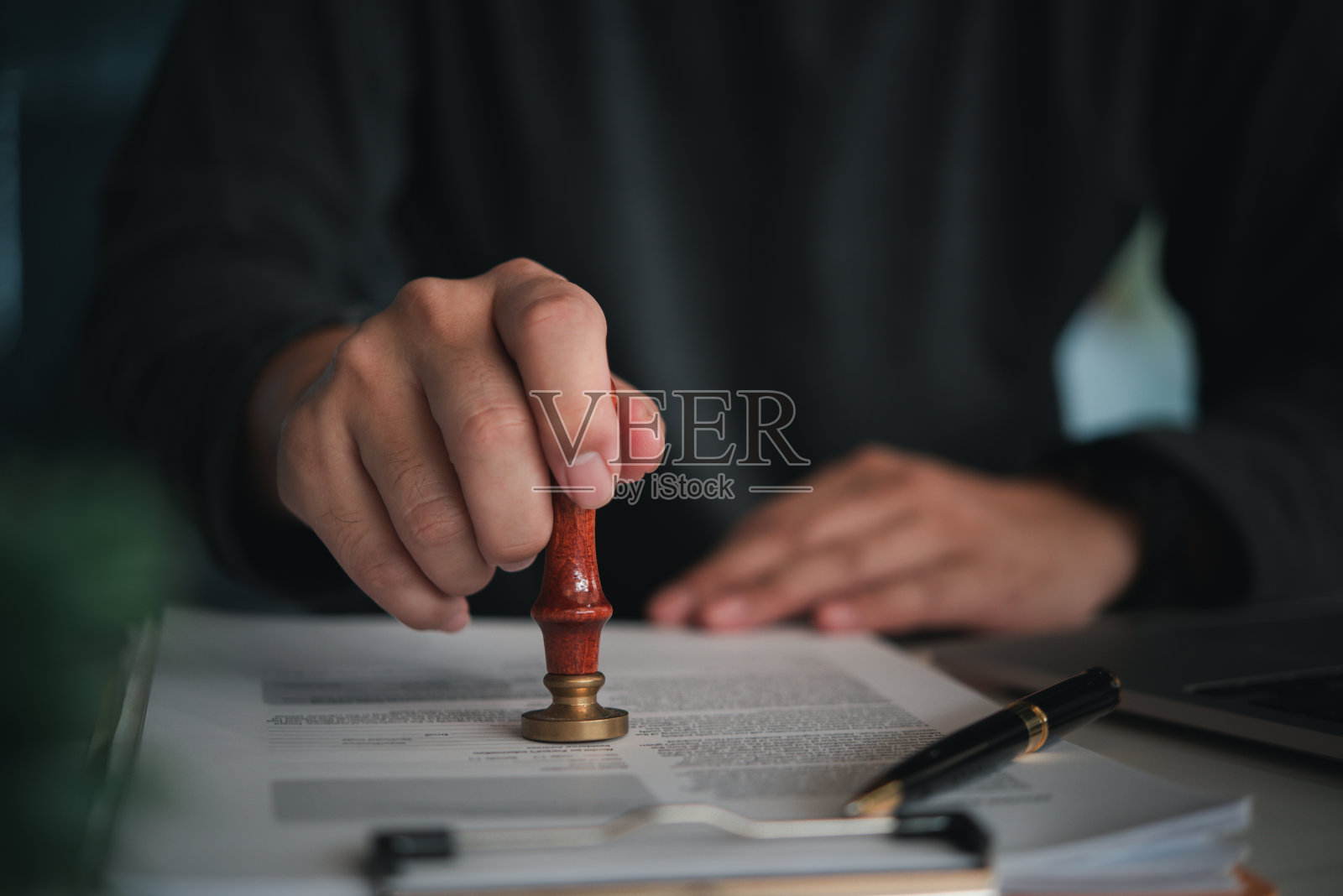 在专业环境下，专注的个人在官方文件上加盖红蜡章照片摄影图片