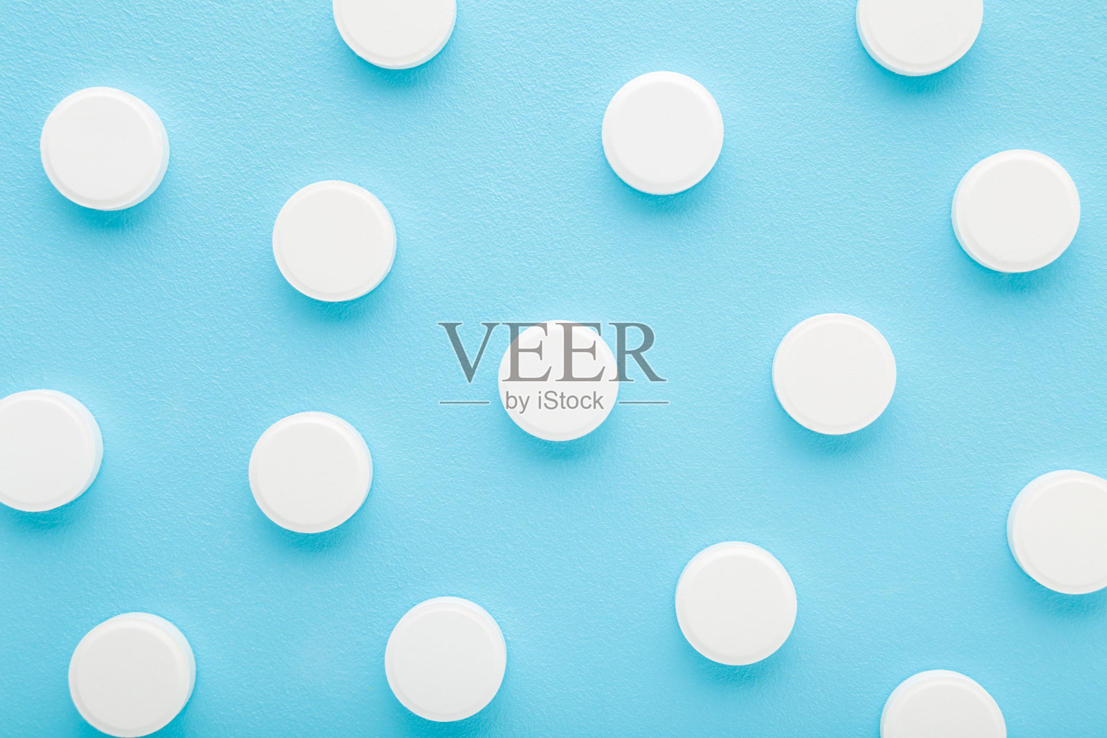 浅蓝色桌面背景上的白色维生素c药片。柔和的颜色。特写镜头。营养补充剂模式。自顶向下视图。照片摄影图片