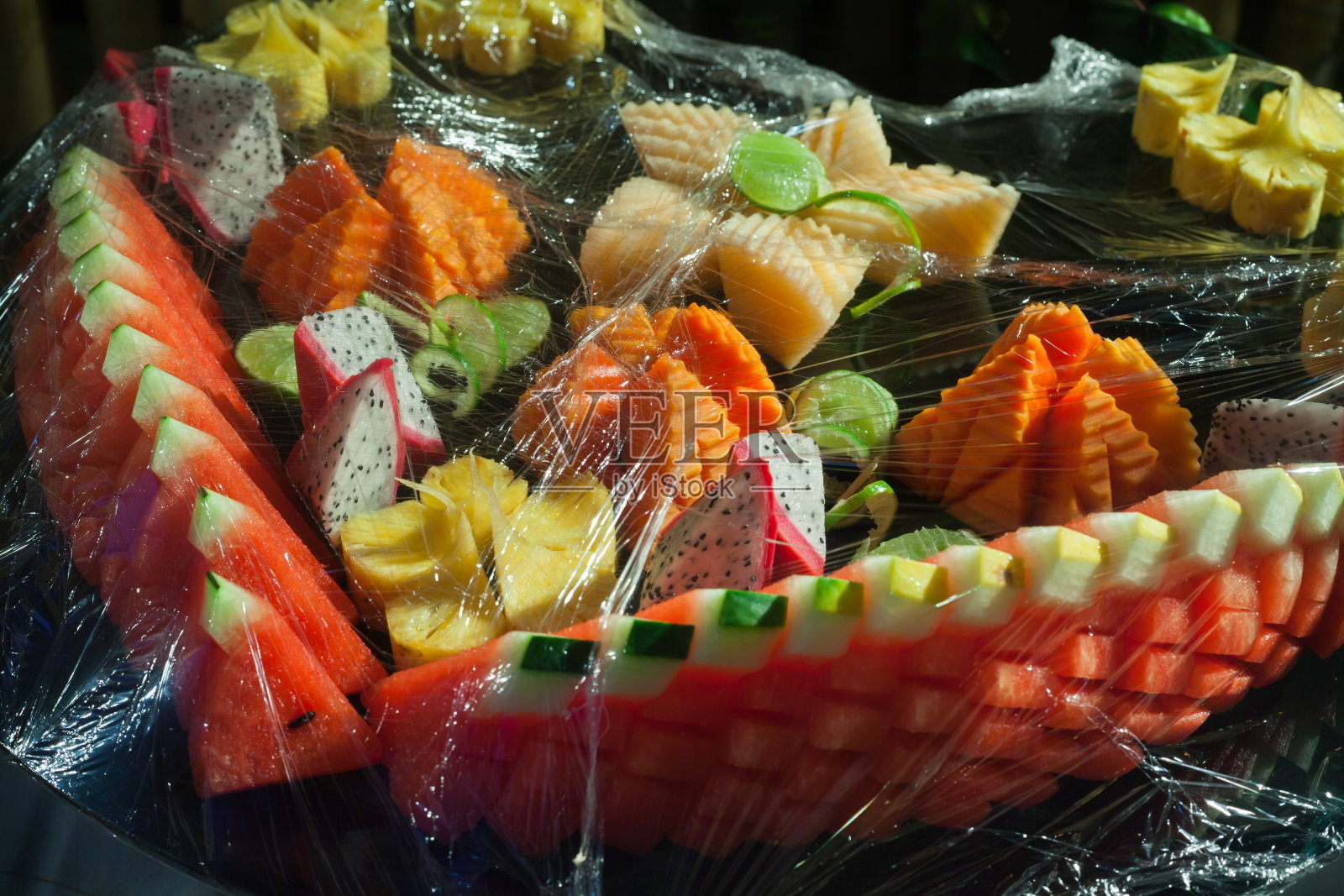 什锦水果，用保鲜膜包起来，供婚宴上的自助餐用。照片摄影图片