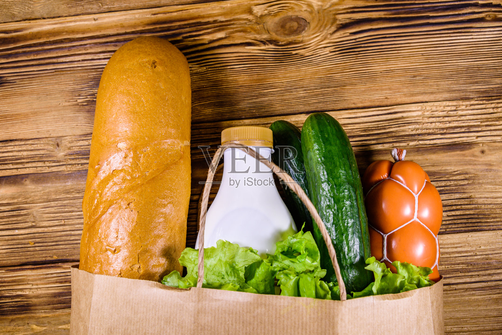 纸袋里装着杂货店里不同的食物，放在木桌上。超市购物理念。俯视图照片摄影图片