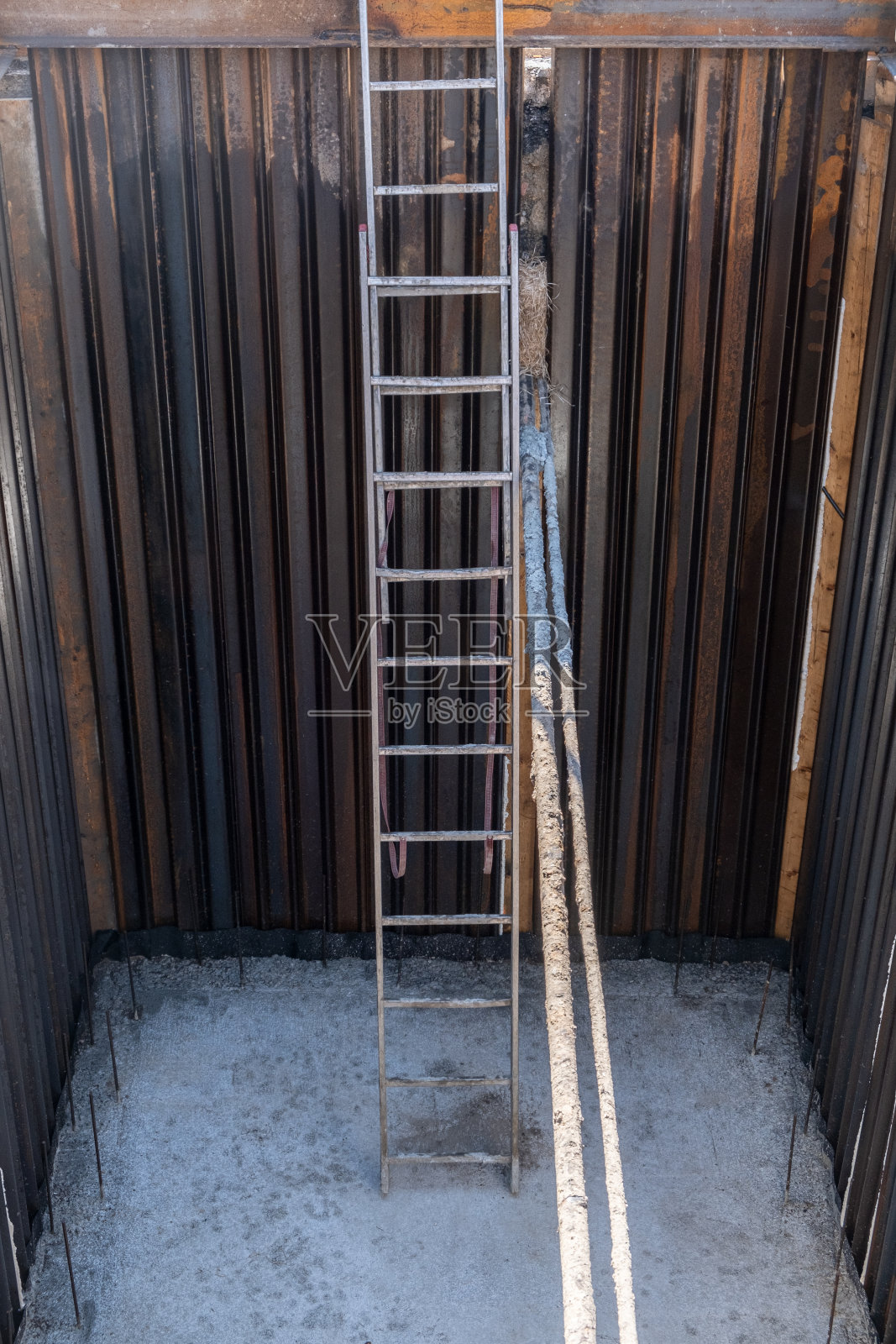 城市街道建筑工地深坑中的梯子，用于基础设施准备照片摄影图片