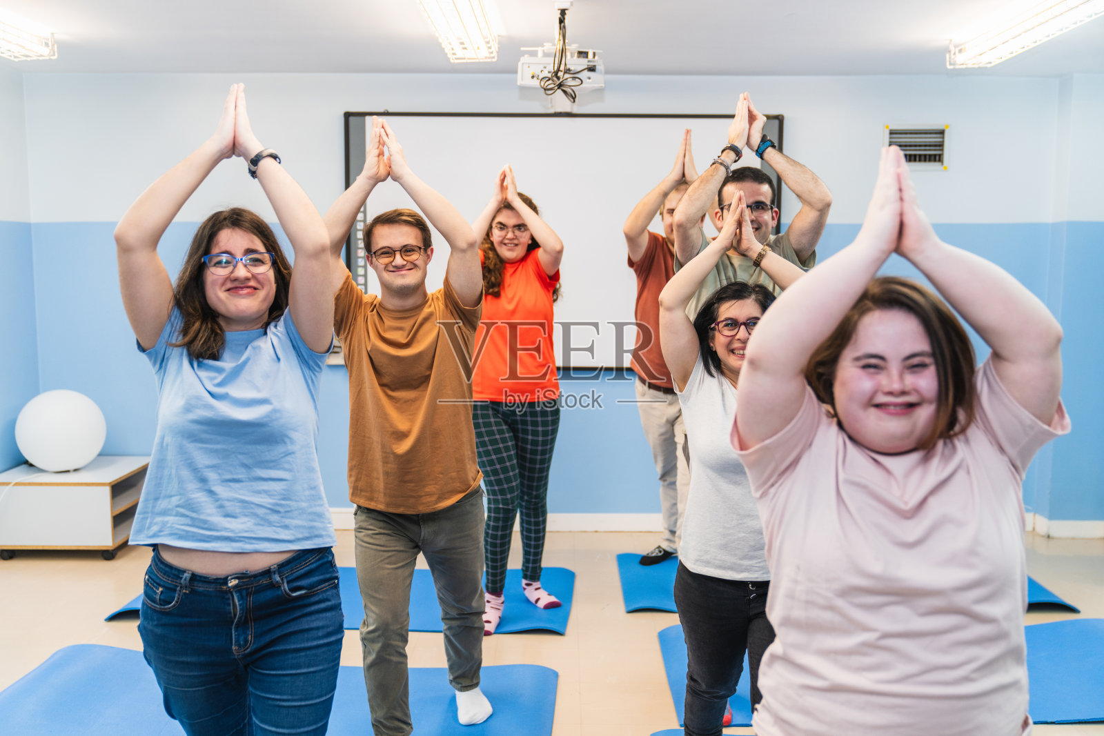 唐氏综合征患者共同参与的包容性瑜伽课程照片摄影图片