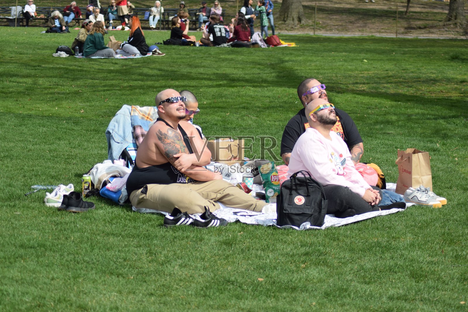 人们在曼哈顿中央公园仰望日食照片摄影图片