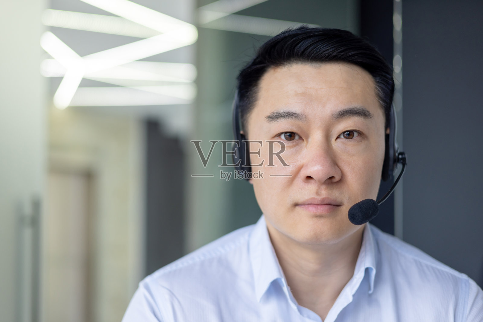 专注的亚洲人，戴着耳机在办公室工作照片摄影图片