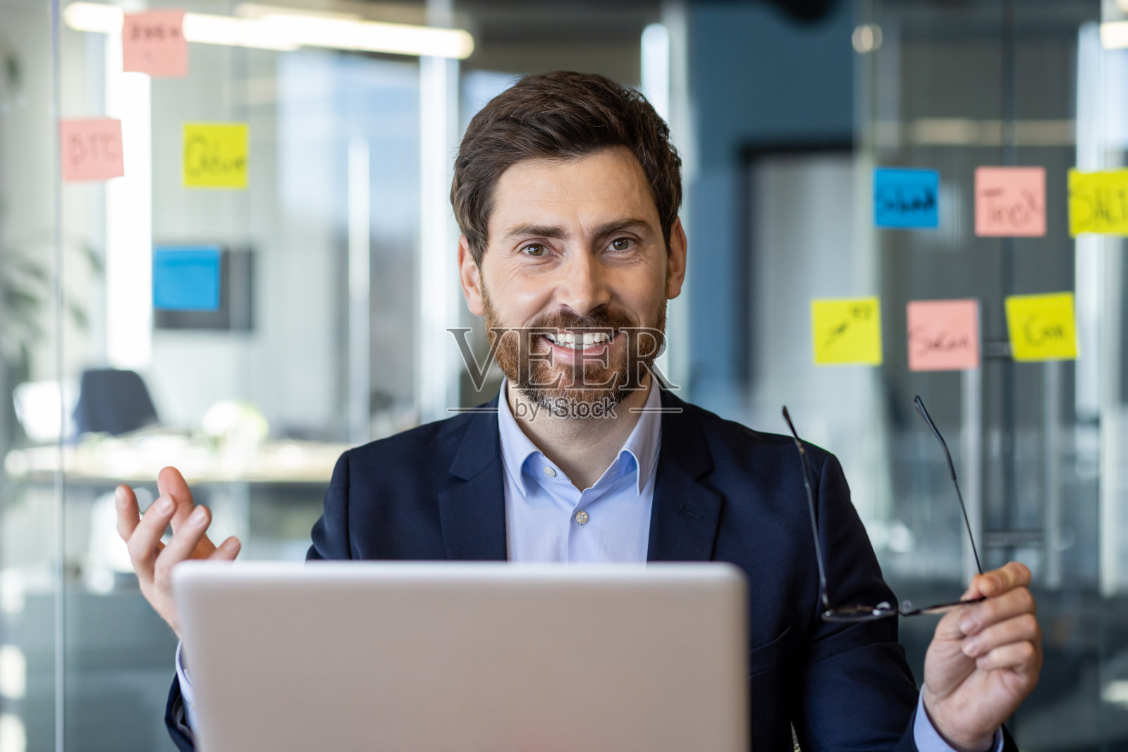 办公室里的商人拿着笔记本和便利贴照片摄影图片