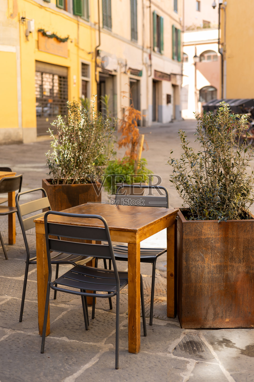 户外街头咖啡馆的桌子随时准备服务。空无一人的咖啡馆露台，木桌和塑料椅，早晨。食品的概念照片摄影图片