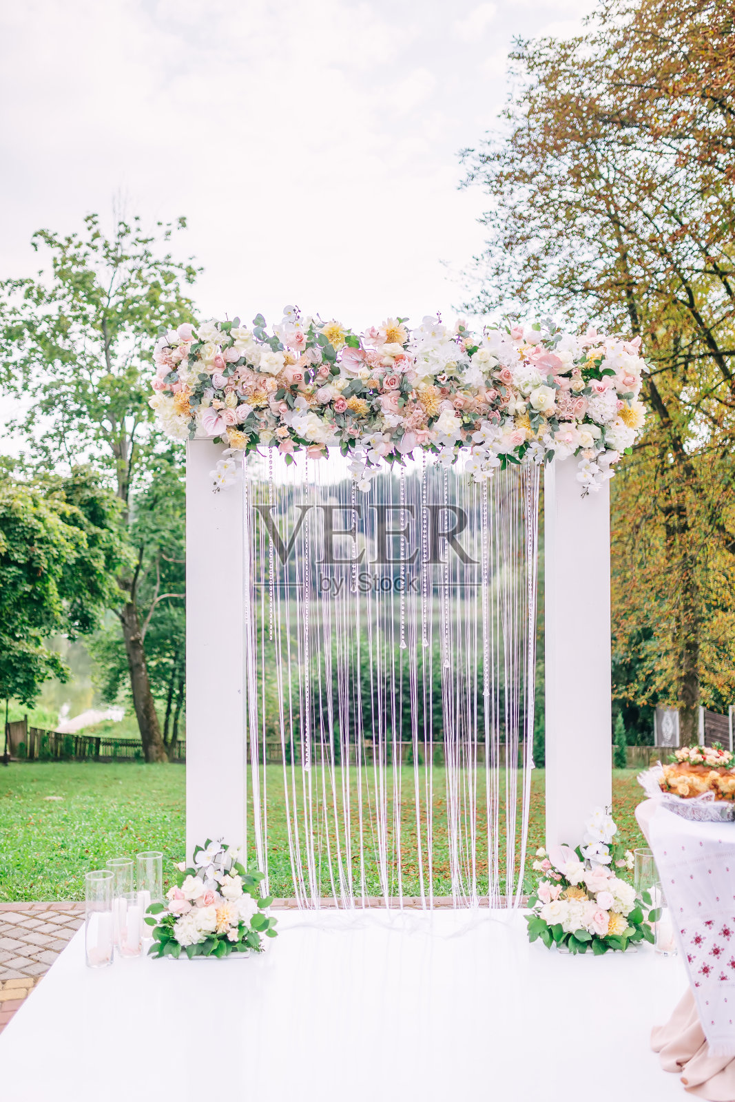 户外草坪花园中的鲜花装饰婚礼拱门照片摄影图片