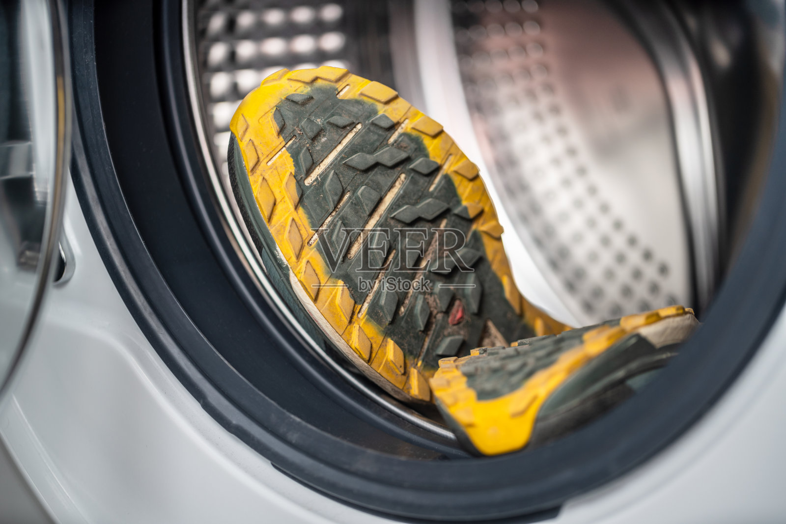 一双脏的越野跑运动鞋在洗衣机里。运动及鞋类卫生。照片摄影图片