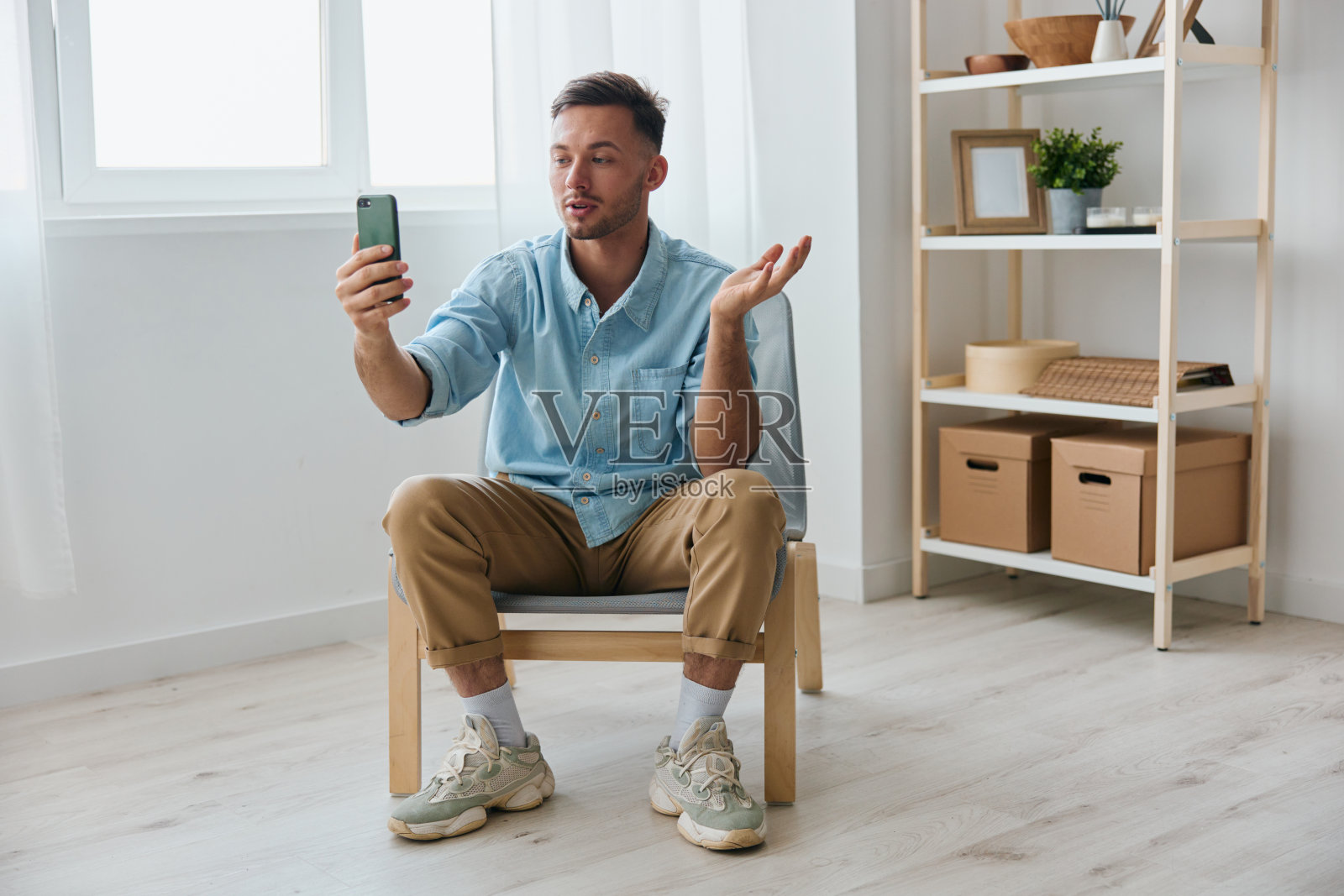 自信快乐开朗地向观众讲述自己的事业迷人的年轻人看着屏幕拿着手机记录视频回顾在家里。新职业在线影响者博主概念照片摄影图片