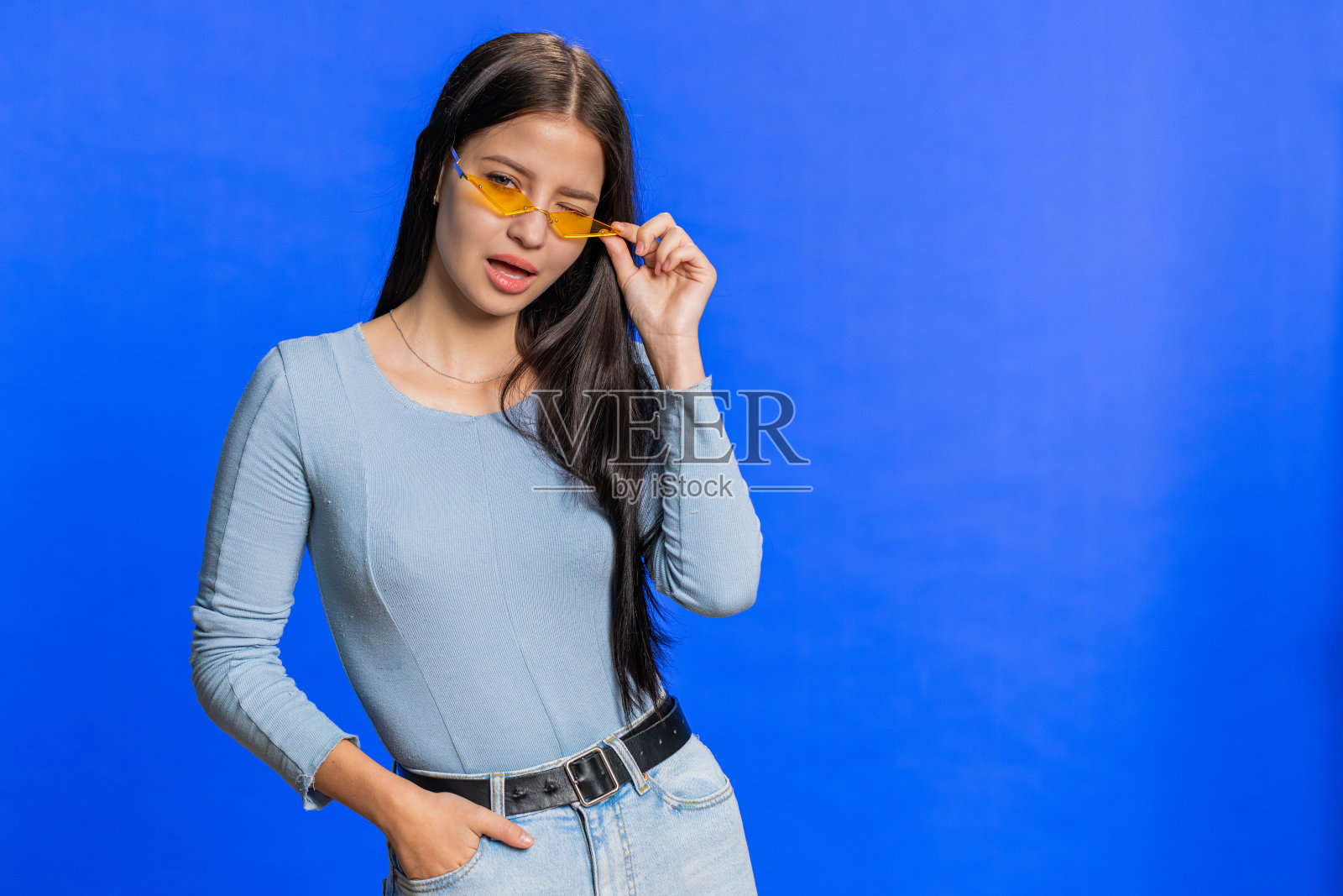 高加索年轻时尚酷女人戴着黄色太阳镜，迷人友好俏皮的微笑照片摄影图片