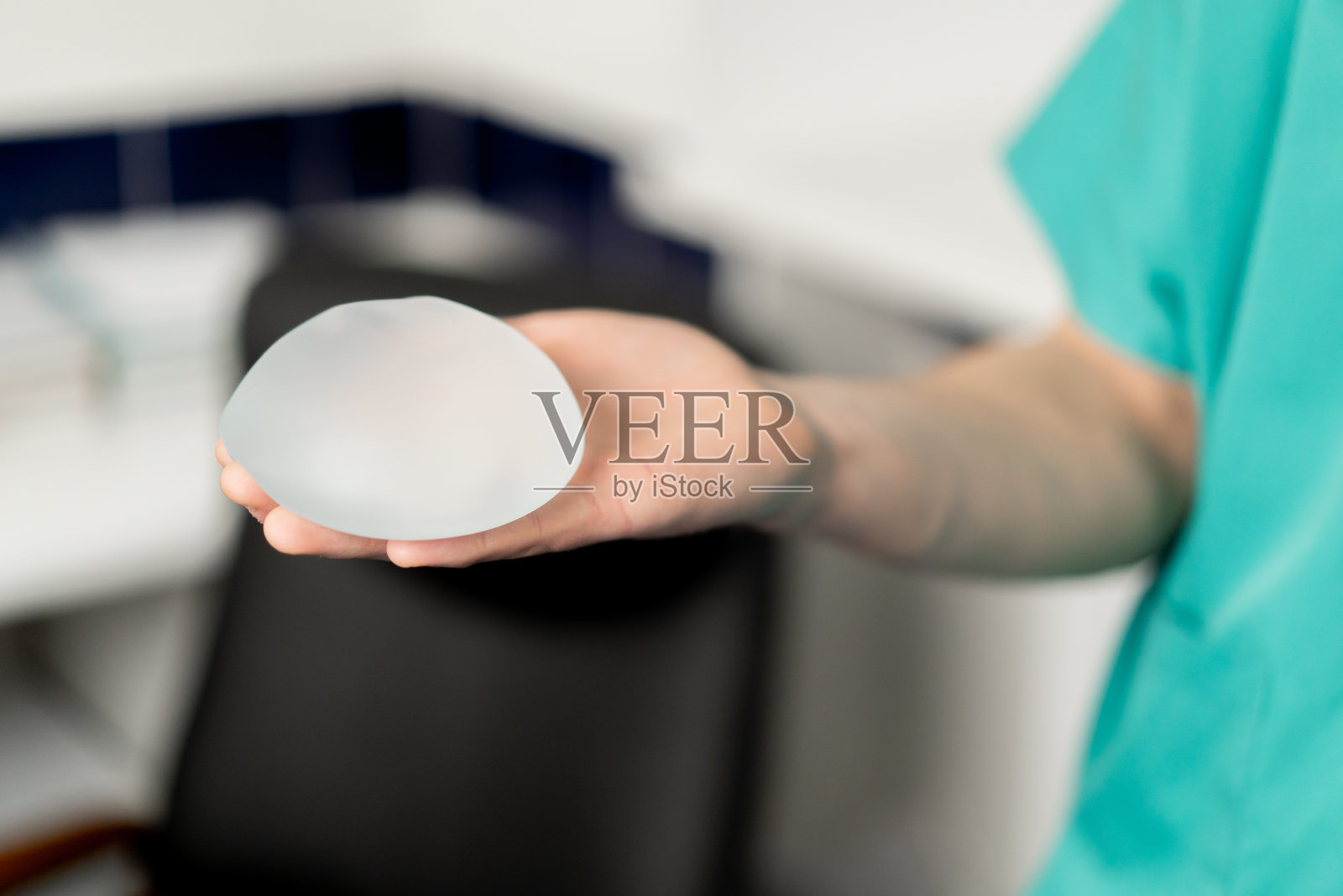 整形外科诊所里，医生手里拿着一个植入物照片摄影图片