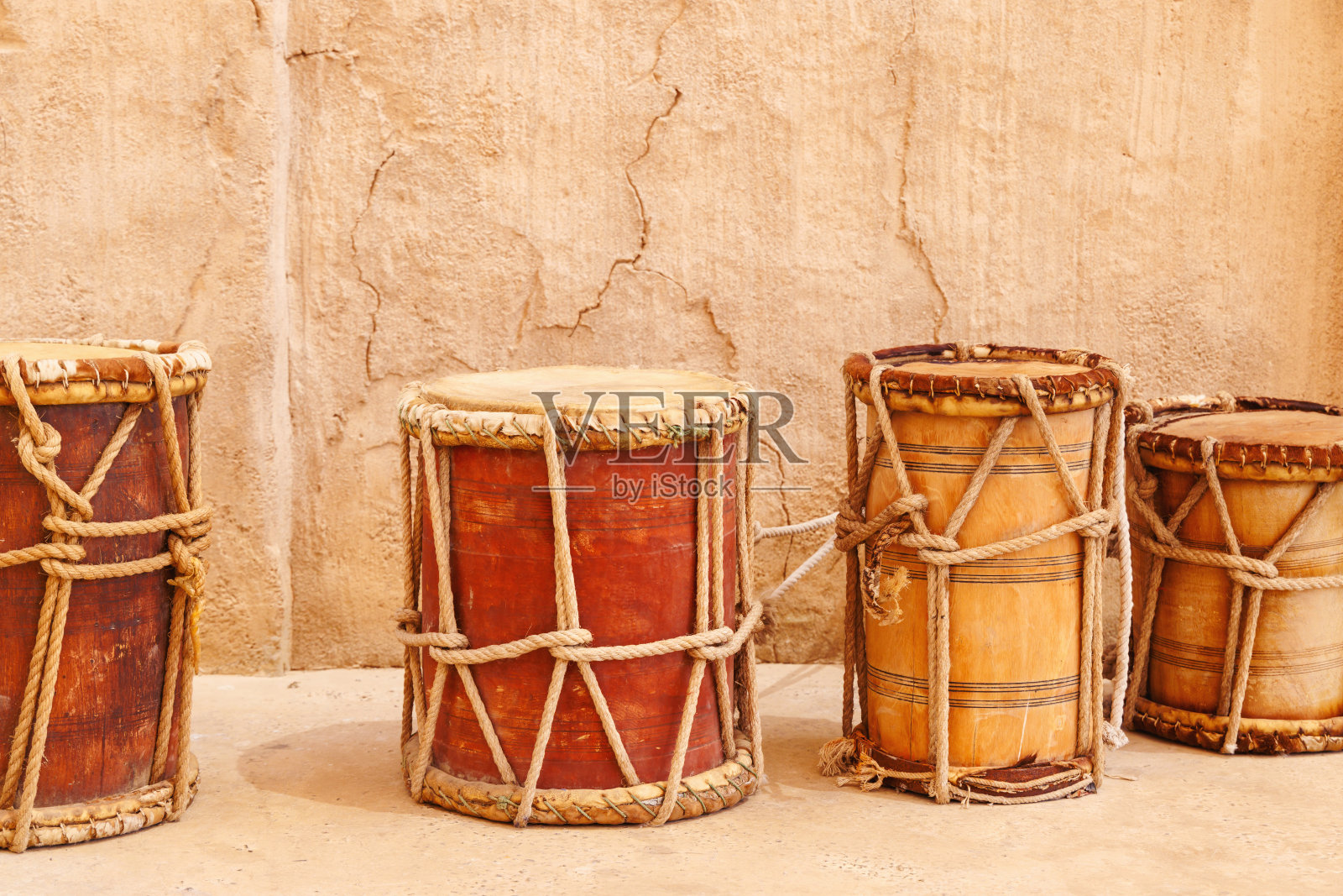 旧墙背景上的老式木鼓。传统的地中海乐器照片摄影图片