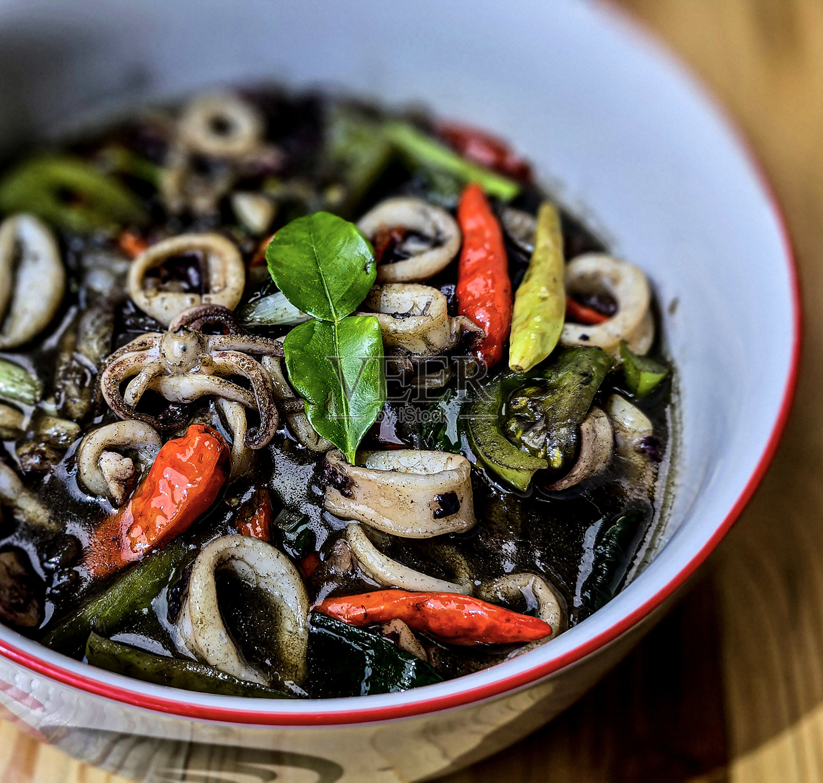 印尼家常菜菜单，用黑墨酱炒鱿鱼，加上一种叫Tumis Cumi Hitam的辣味调料，包括辣椒、生姜和酸橙叶照片摄影图片