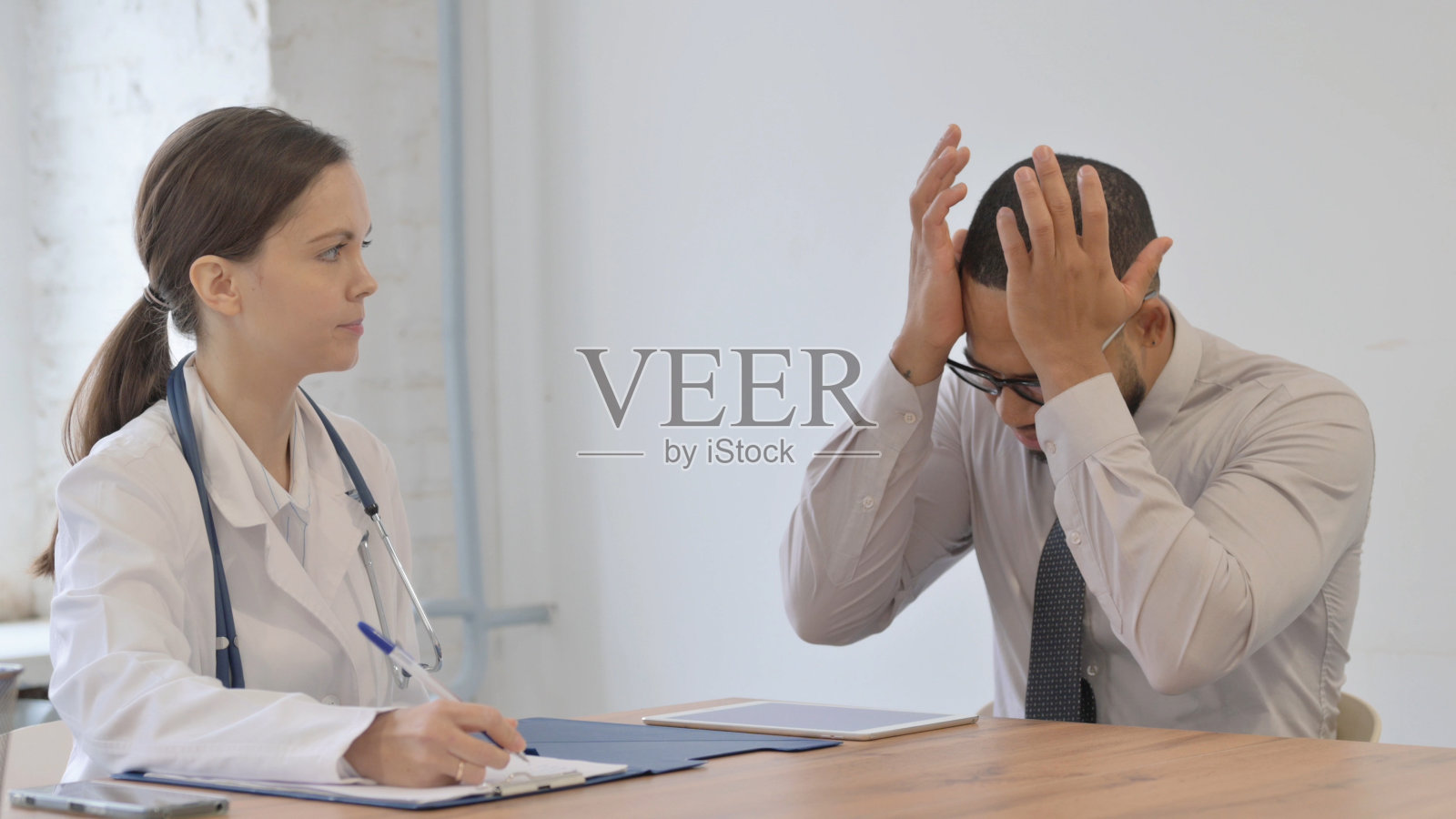 头痛男子向女医生求诊照片摄影图片