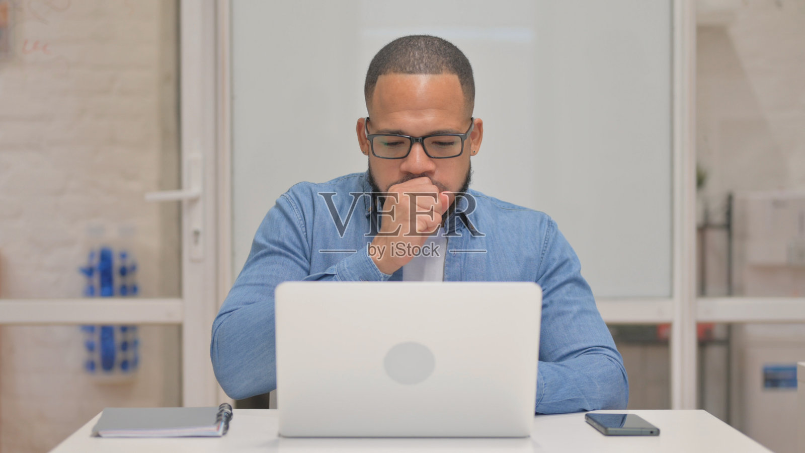 咳嗽的混血儿使用笔记本电脑照片摄影图片