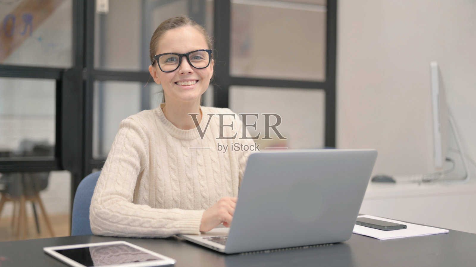 年轻女子在办公室对着镜头微笑照片摄影图片