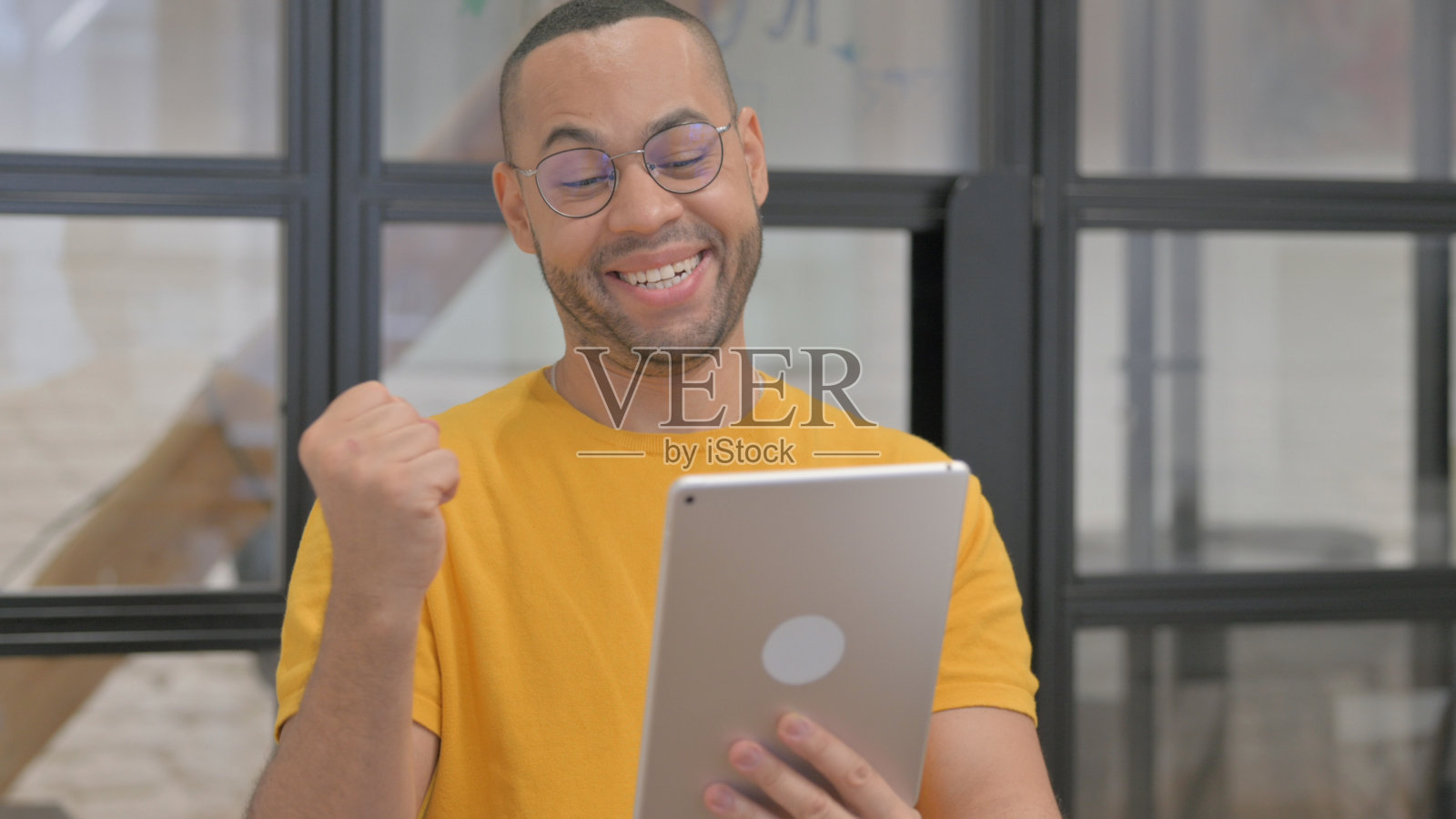 在平板电脑上庆祝成功的混血儿肖像照片摄影图片