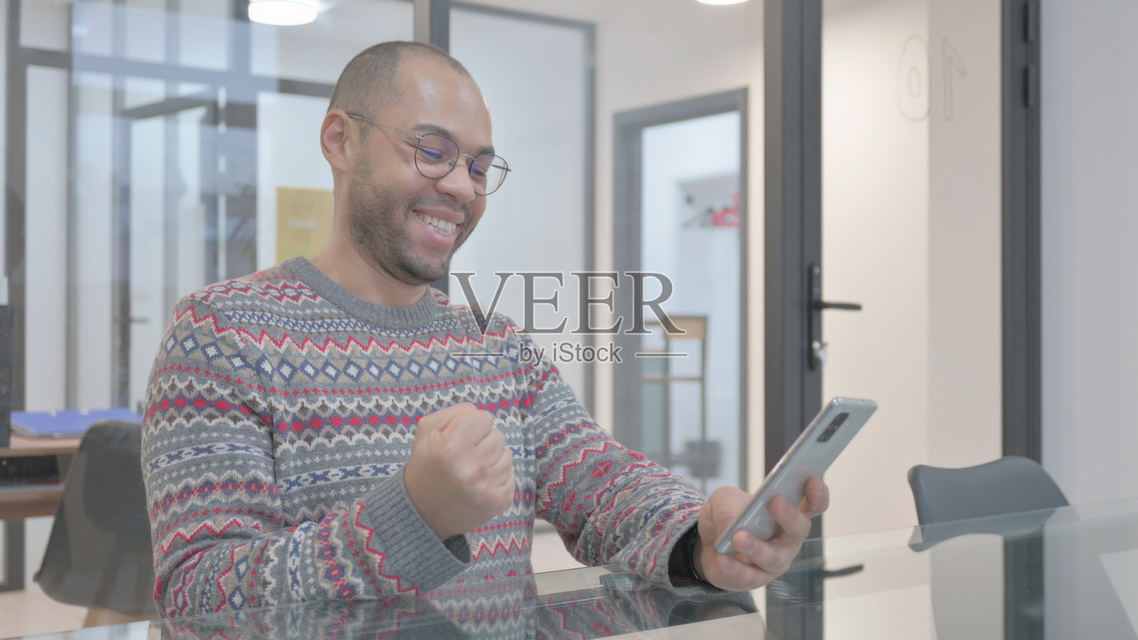 年轻的西班牙人在电话里庆祝成功照片摄影图片