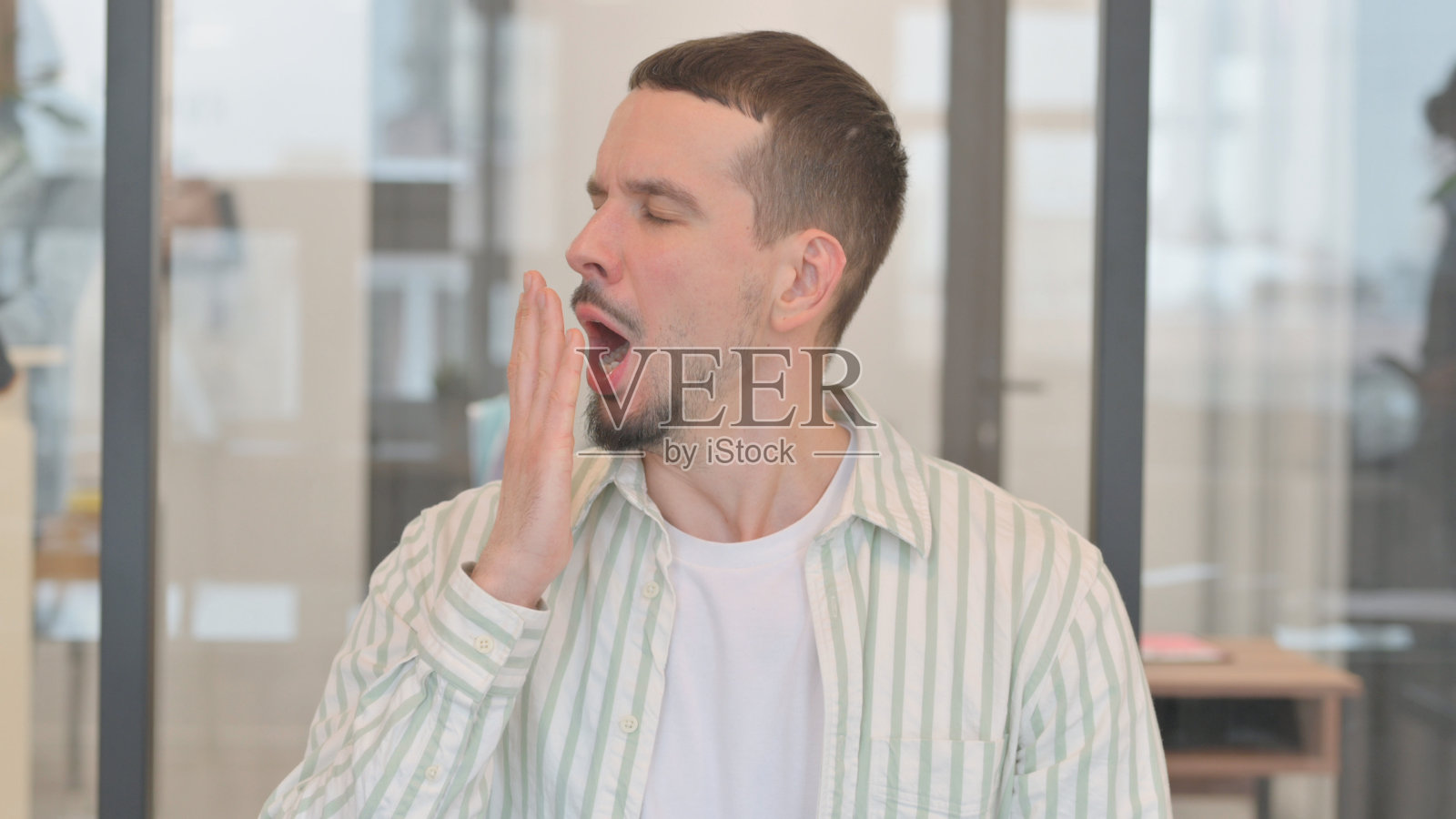 打哈欠、疲倦、富有创造力的年轻人的肖像照片摄影图片