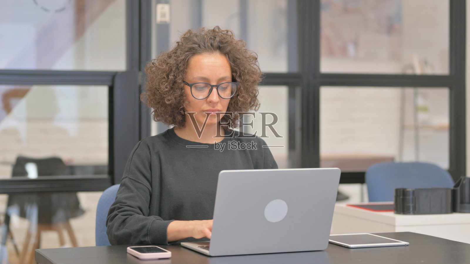 混血女性在办公室用笔记本电脑工作照片摄影图片