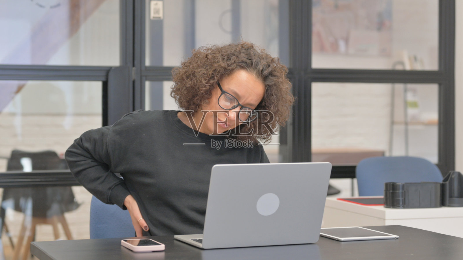 工作的混血女性背部疲劳和疼痛照片摄影图片