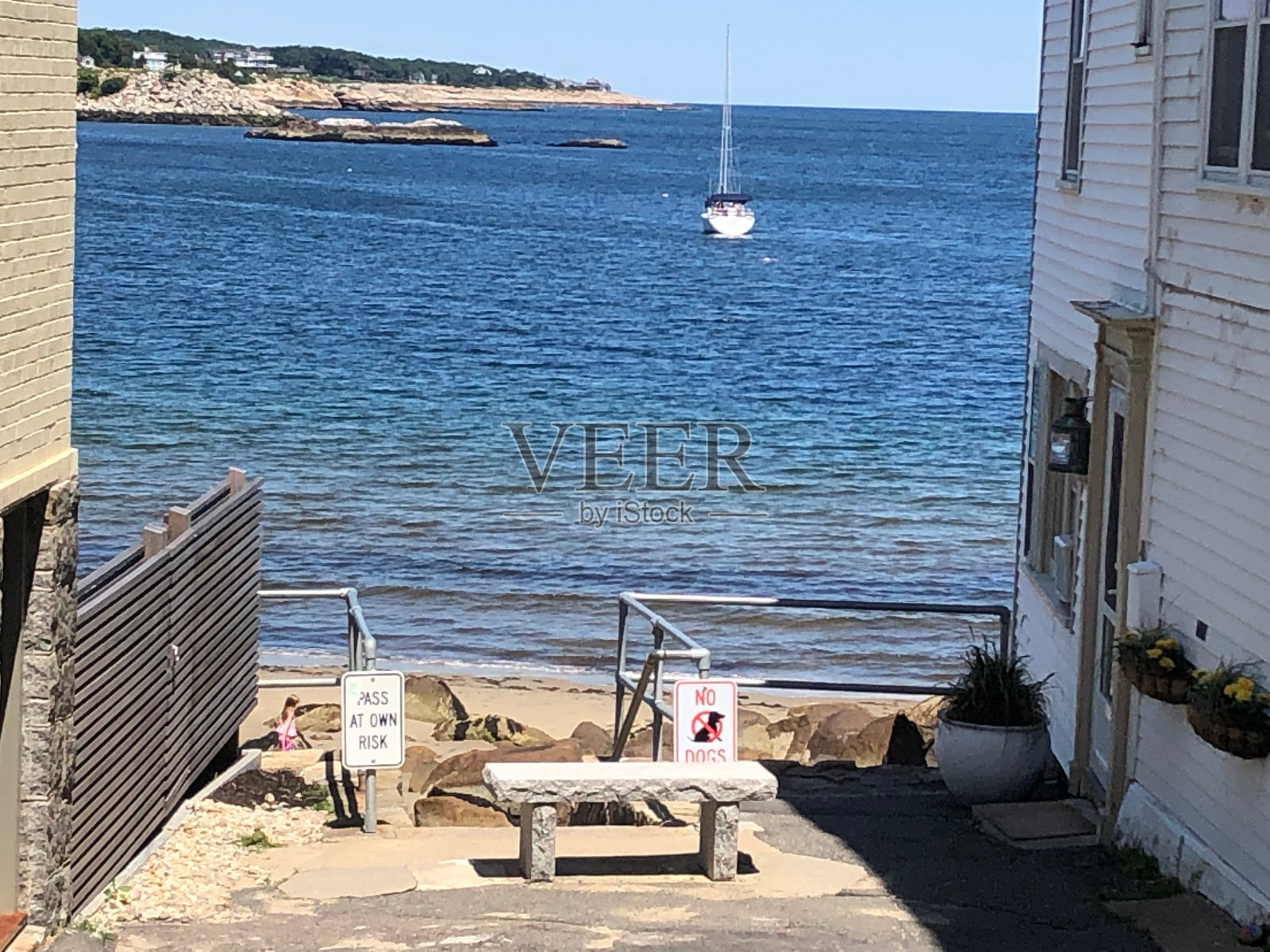 在马萨诸塞州罗克波特，可以看到海滩和港口的小巷照片摄影图片