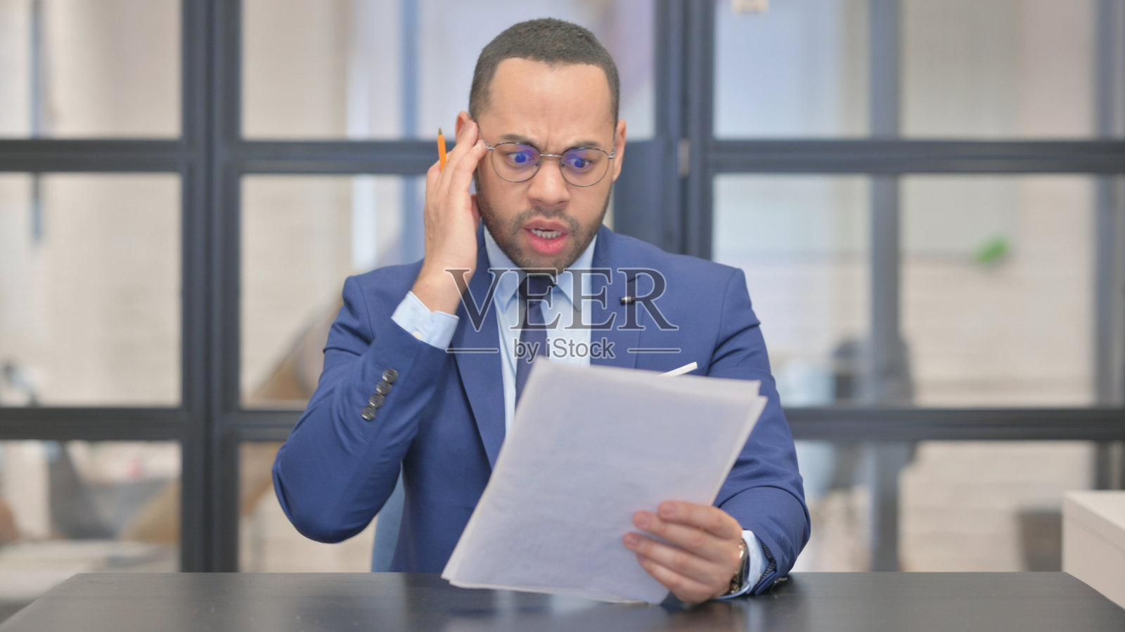 混血商人阅读合同时感到不安照片摄影图片